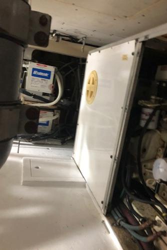 Engine room of a 1997 Bertram Convertible boat with battery and machinery.