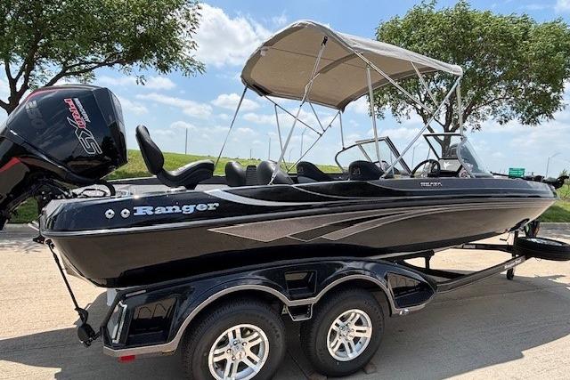 2026 Ranger 212LS boat on trailer, black exterior, canopy, parked outdoors under blue sky.