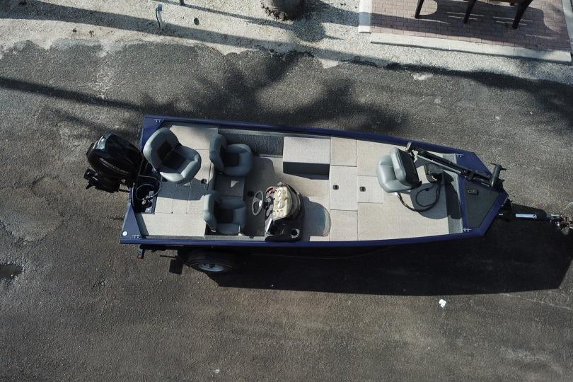 Aerial view of 2020 Tracker Pro 170 boat on pavement, featuring seating and motor.