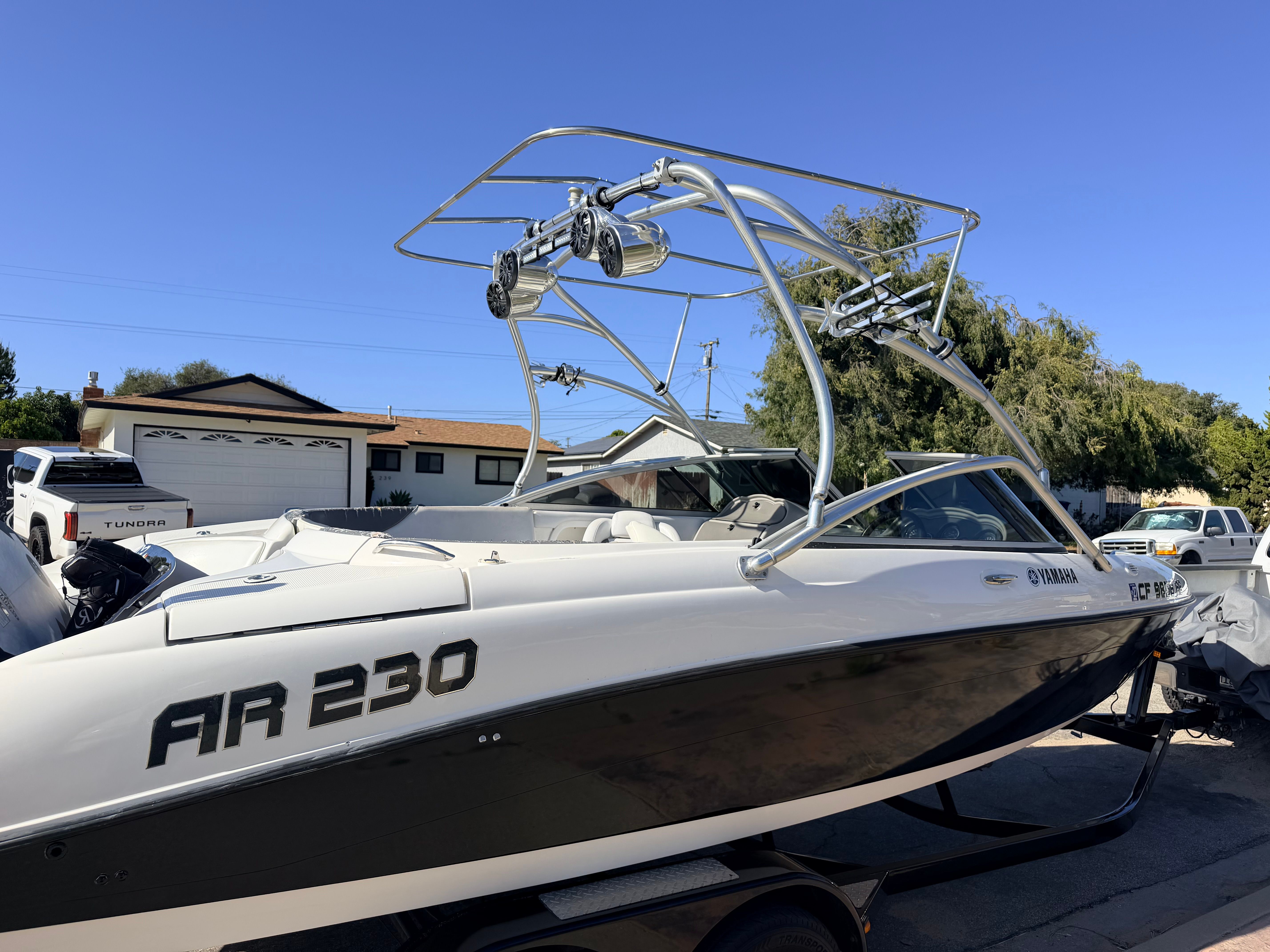 A 2005 Yamaha AR230 boat on a trailer in a residential area.