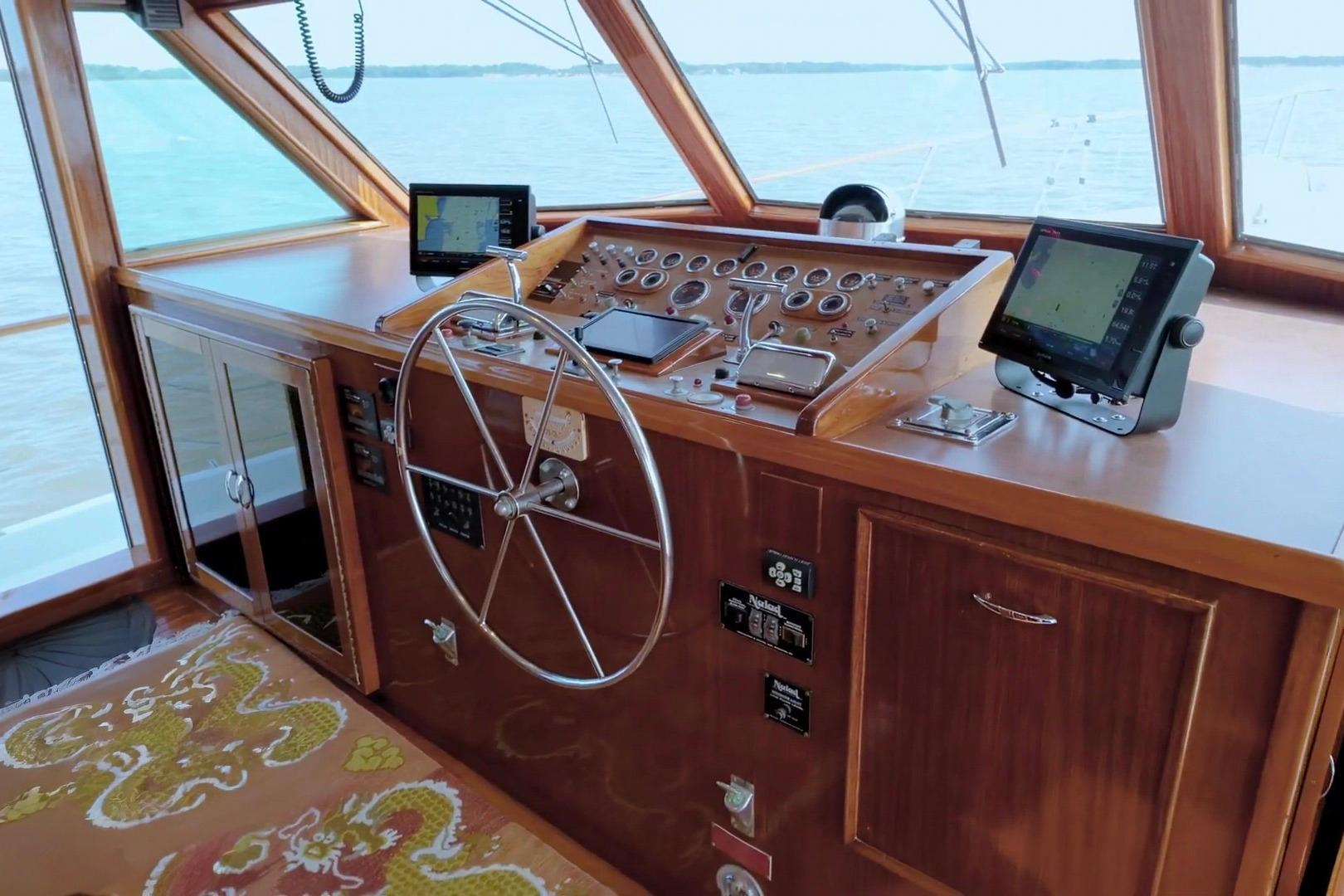 Helm of 1980 Hatteras 70 Motor Yacht with classic wooden dashboard and modern navigation equipment.