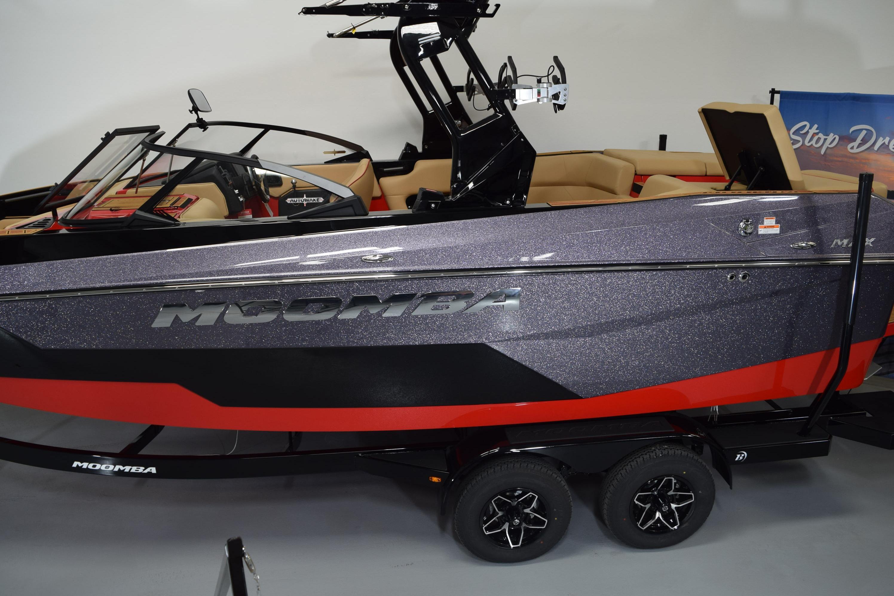 2026 Moomba Max boat with sleek design, black and red accents, on a trailer.