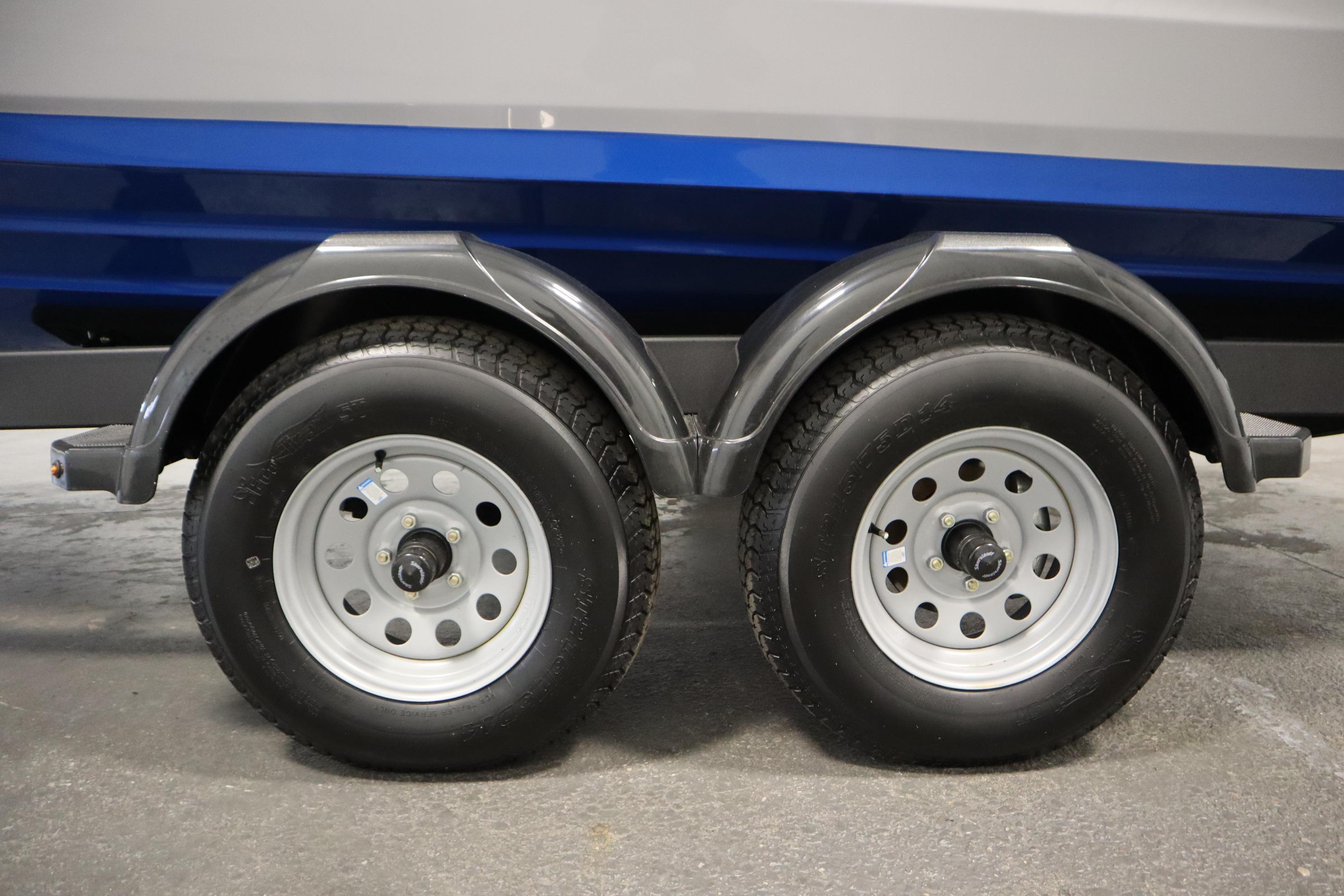 Trailer wheels of a 2026 Yamaha Boats AR220, featuring dual axles and sturdy tires.