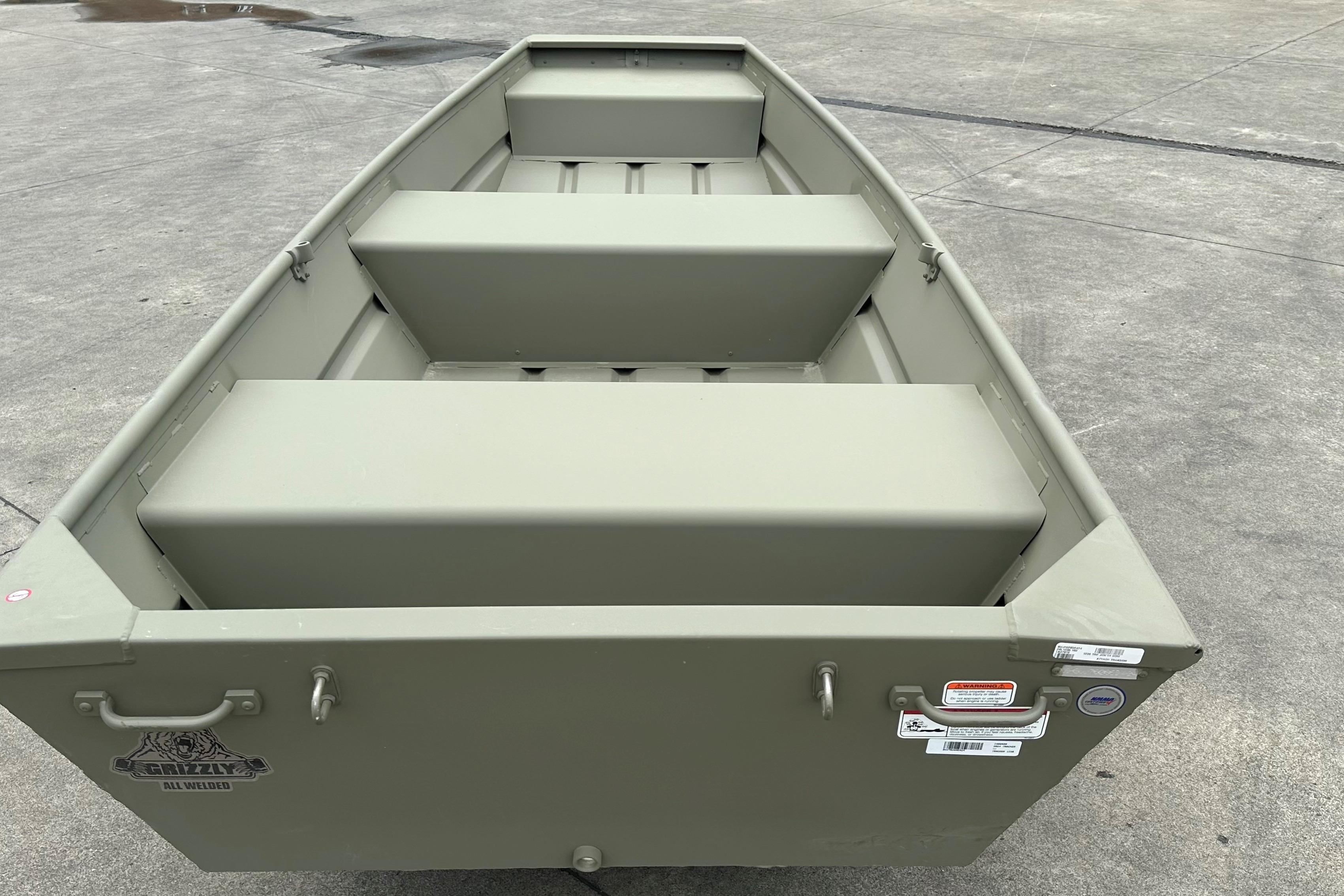 2026 Tracker Grizzly 12 Jon boat on concrete surface, showcasing interior seating and design.