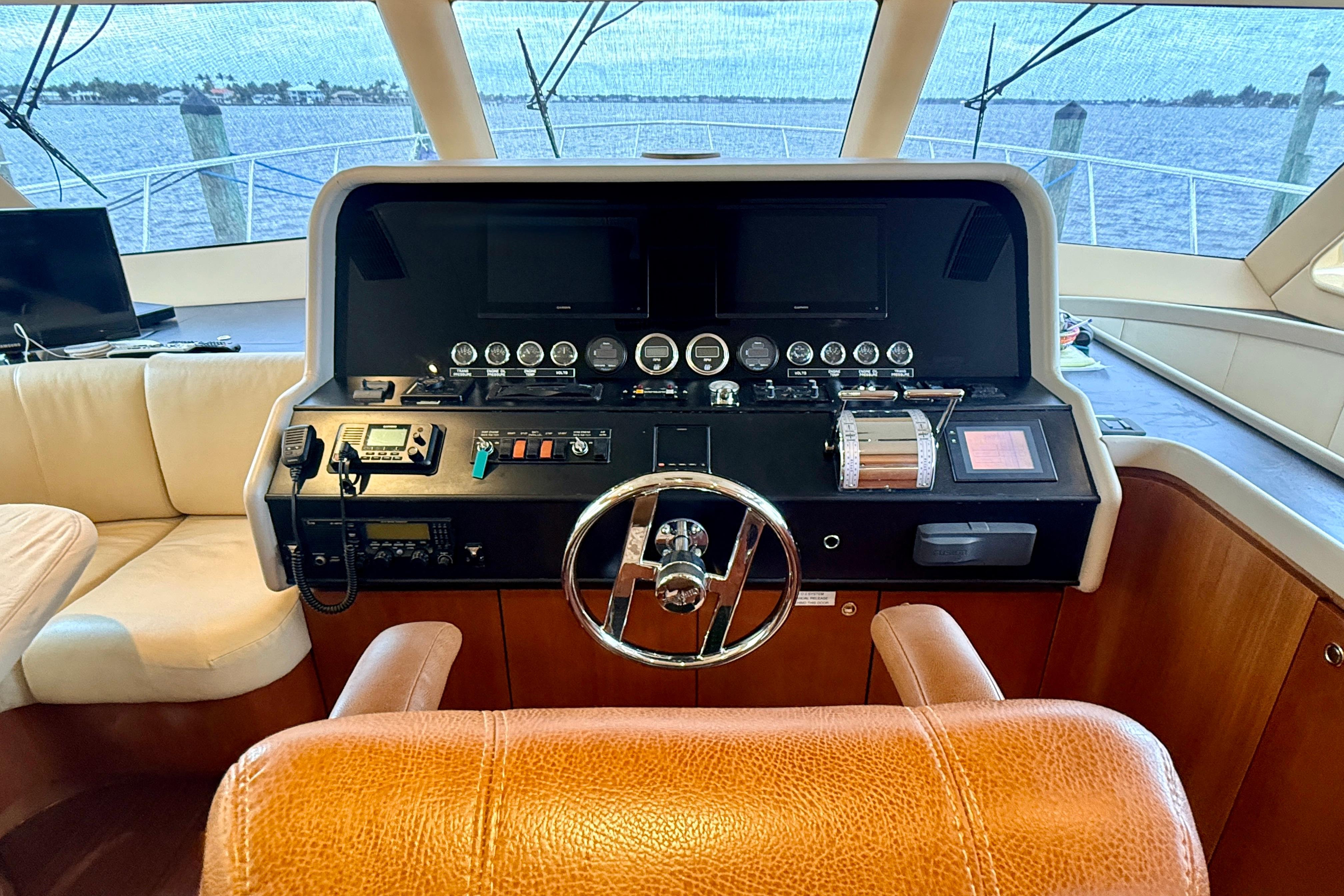 Pilot house of 2002 Cheoy Lee 72 Raised Motor Yacht with steering wheel and control panel.