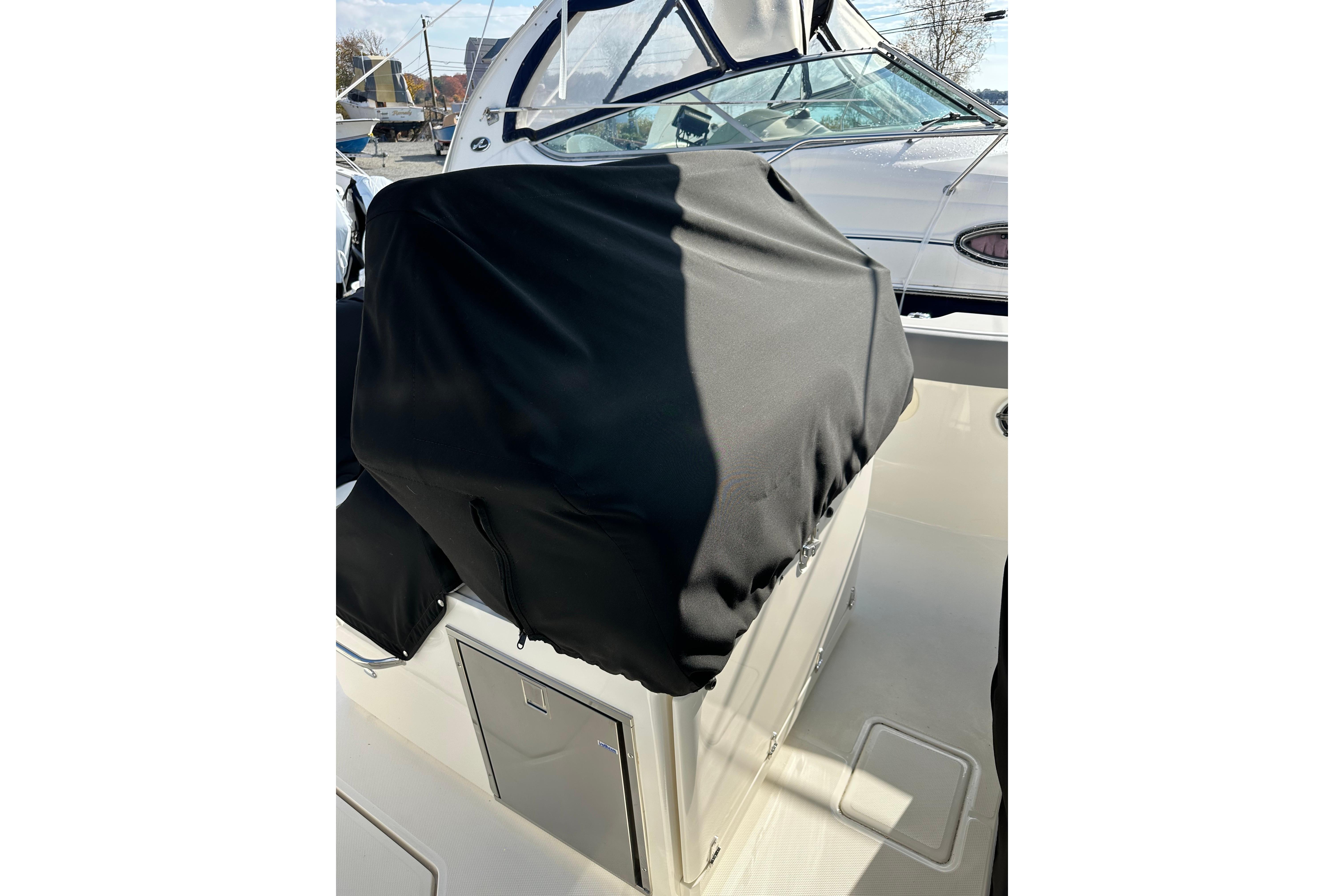2023 Boston Whaler 330 Outrage boat console covered with black protective fabric.