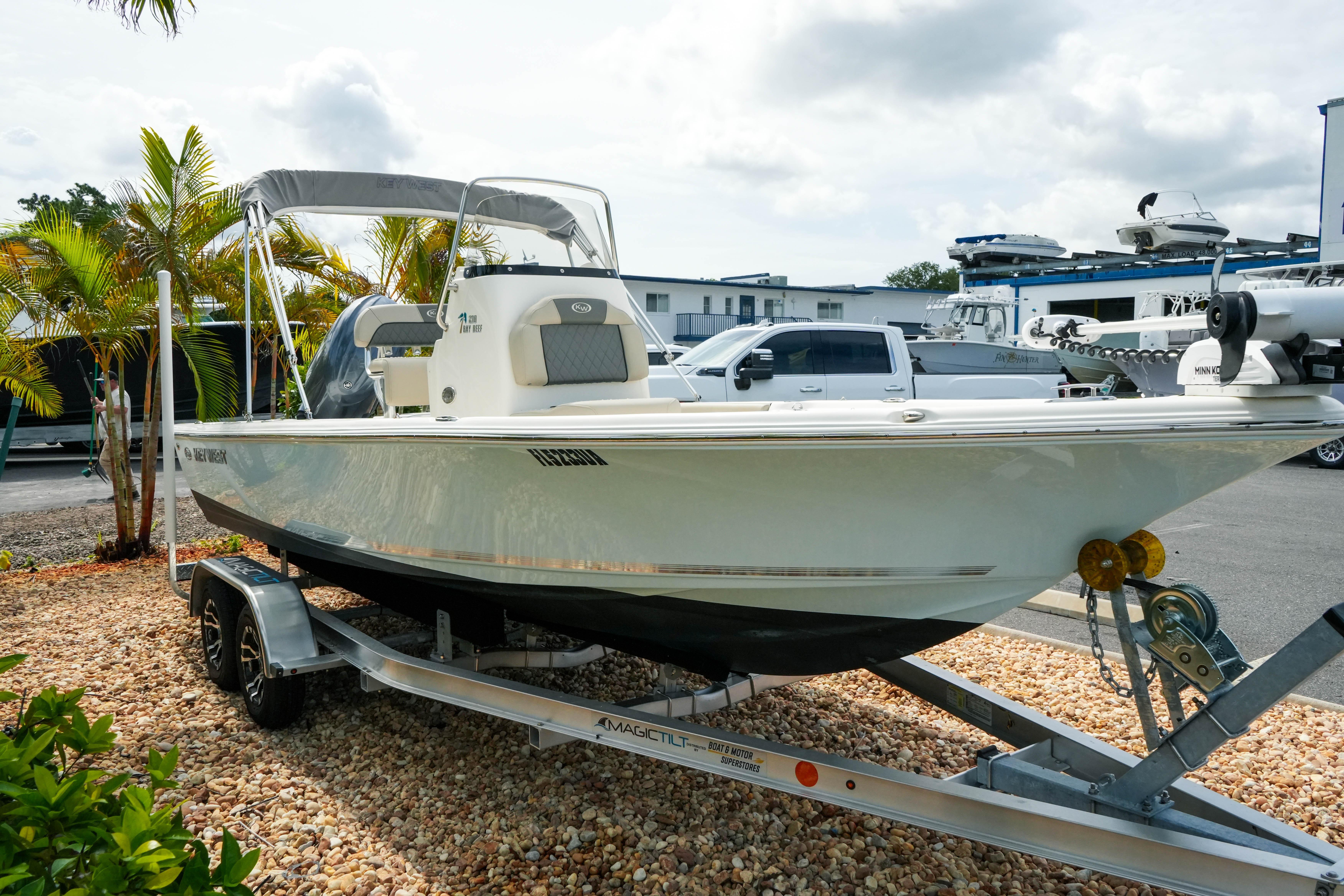 2025 Key West 210 Bay Reef boat on trailer, parked outdoors near palm trees.