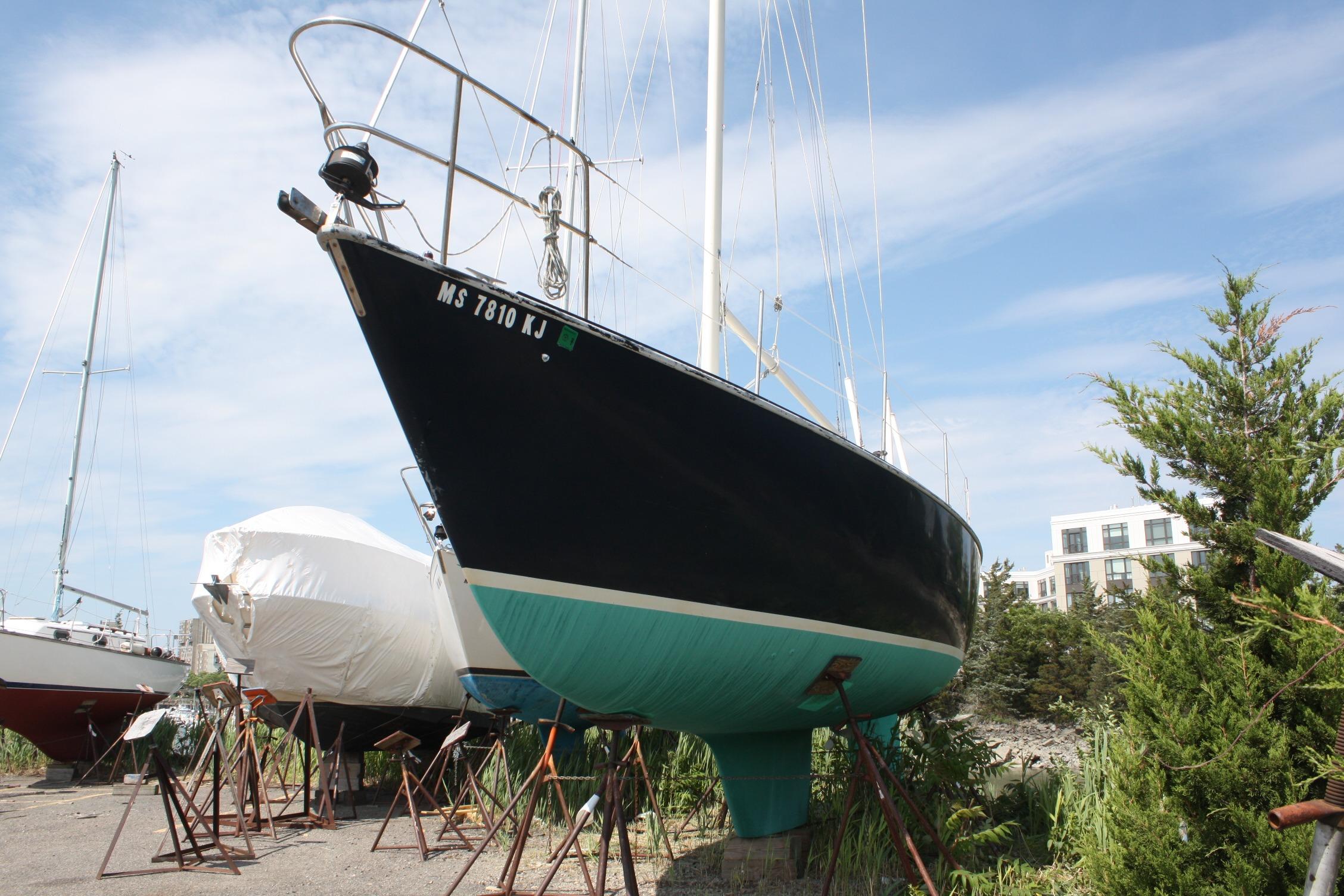 1981 S2 9.2A sailboat on stands, with blue hull and clear sky background.