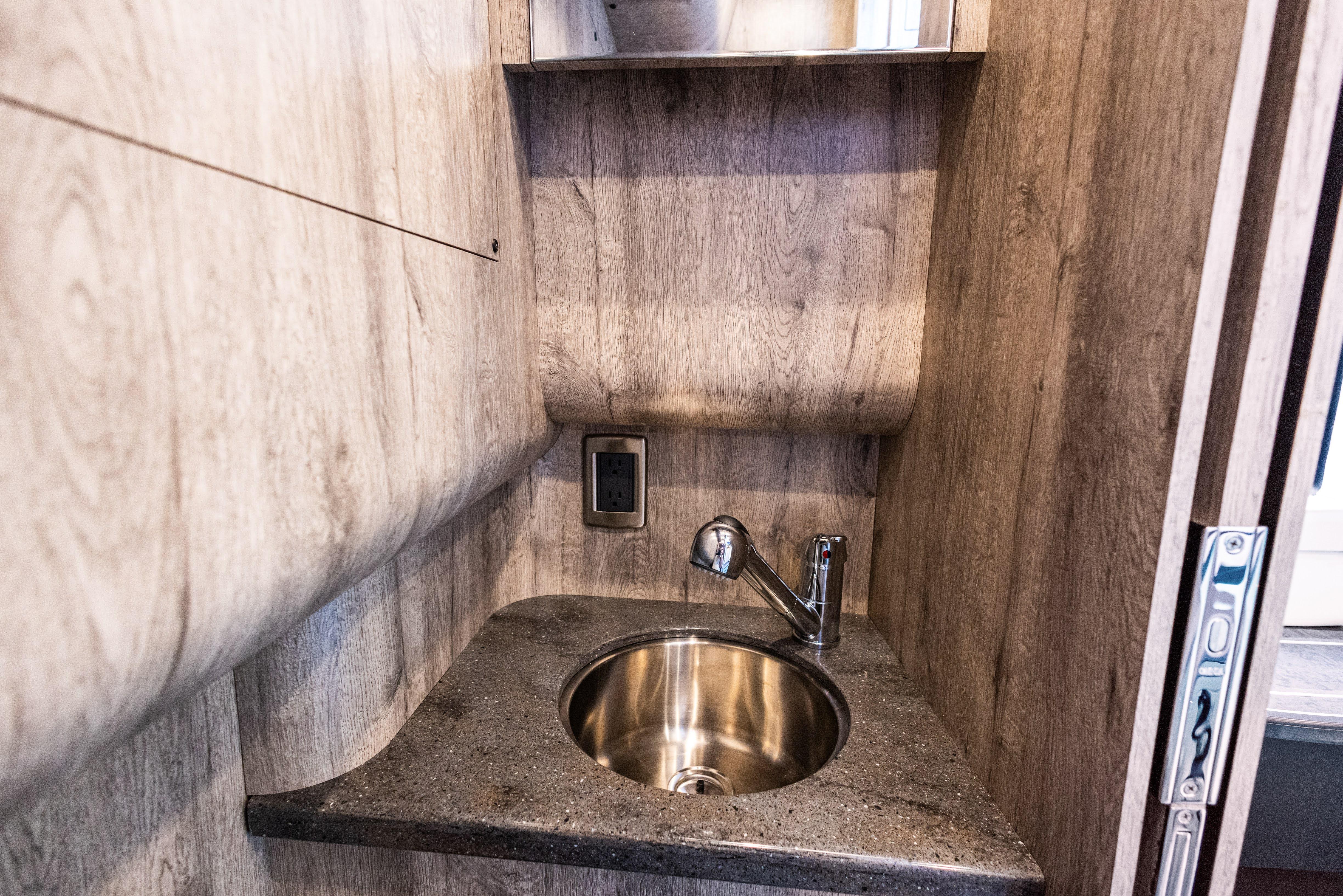 2026 Mystic Powerboats M4200 interior sink with wood paneling and modern faucet.
