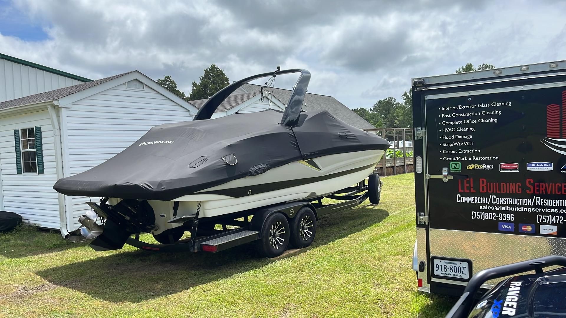 A 2019 Crownline E 285 boat is on a trailer next to a building.
