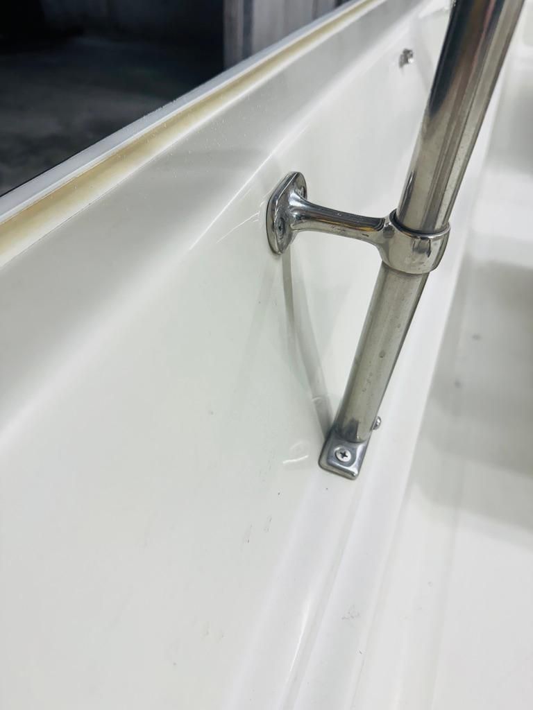 Close-up of a stainless steel handrail on a white boat.
