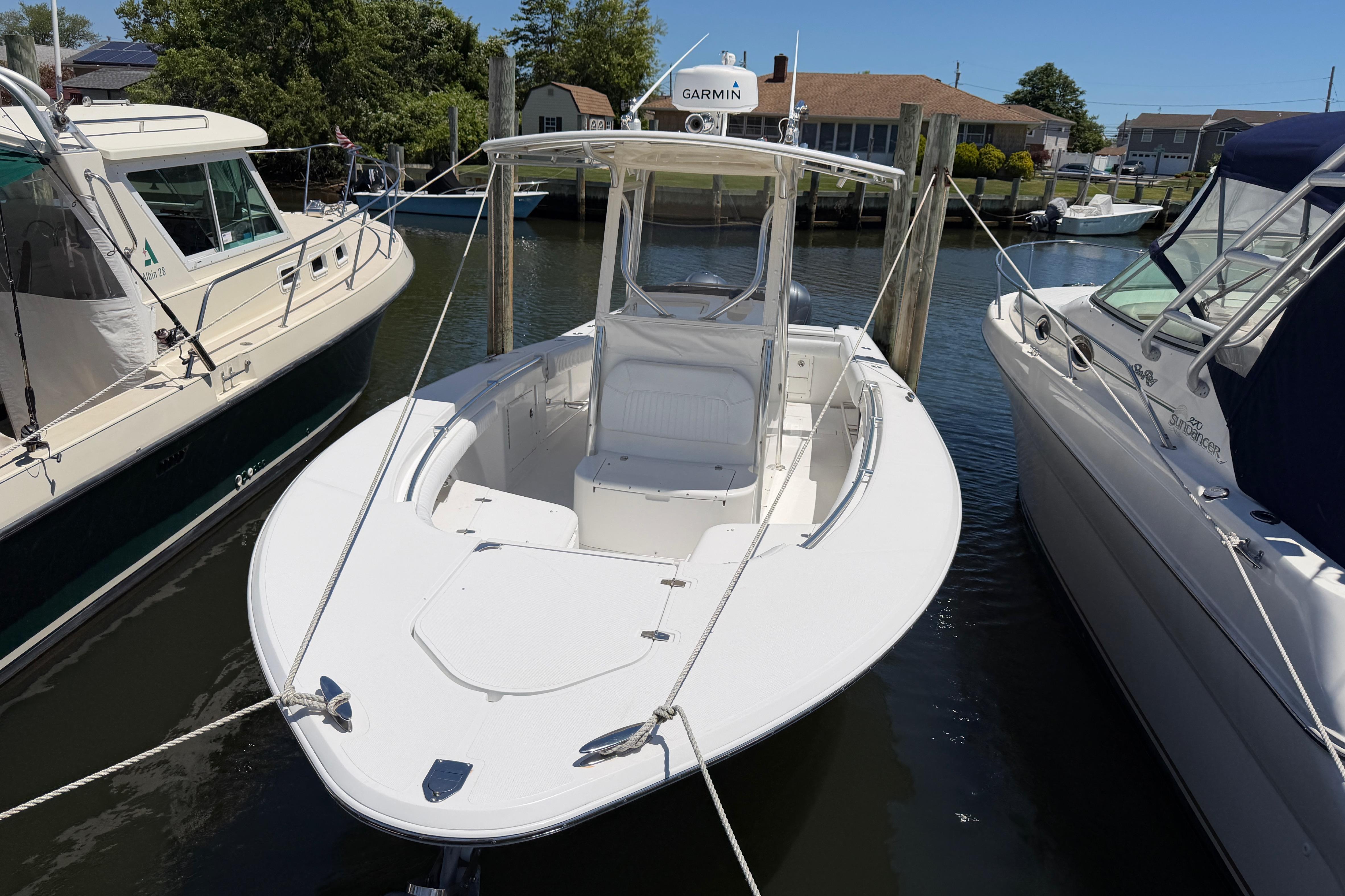 2006 Southport 26 Center Console boat docked between two other boats.