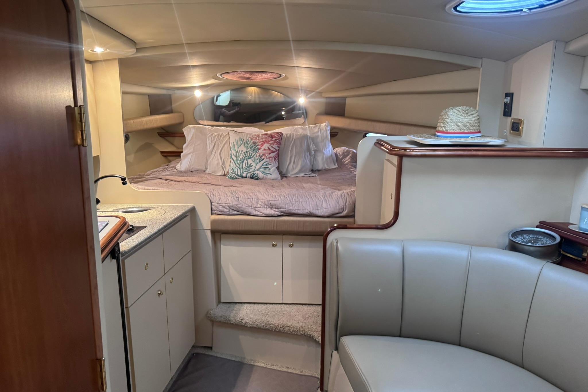 Luxurious interior of 2002 Cruisers Yachts 3275 Express with cozy bed and seating area.