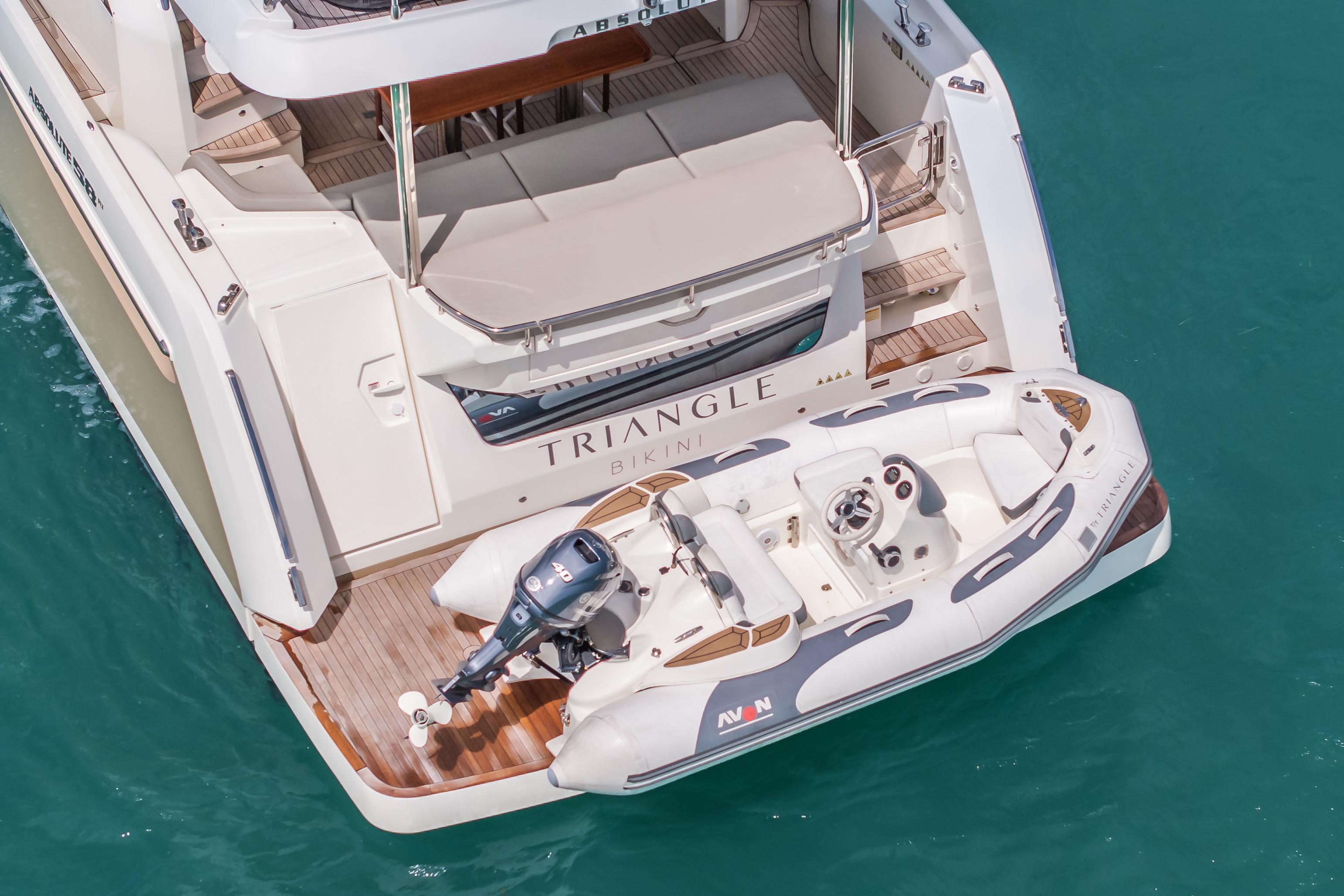 2019 Absolute 58 FLY yacht with tender on turquoise water.
