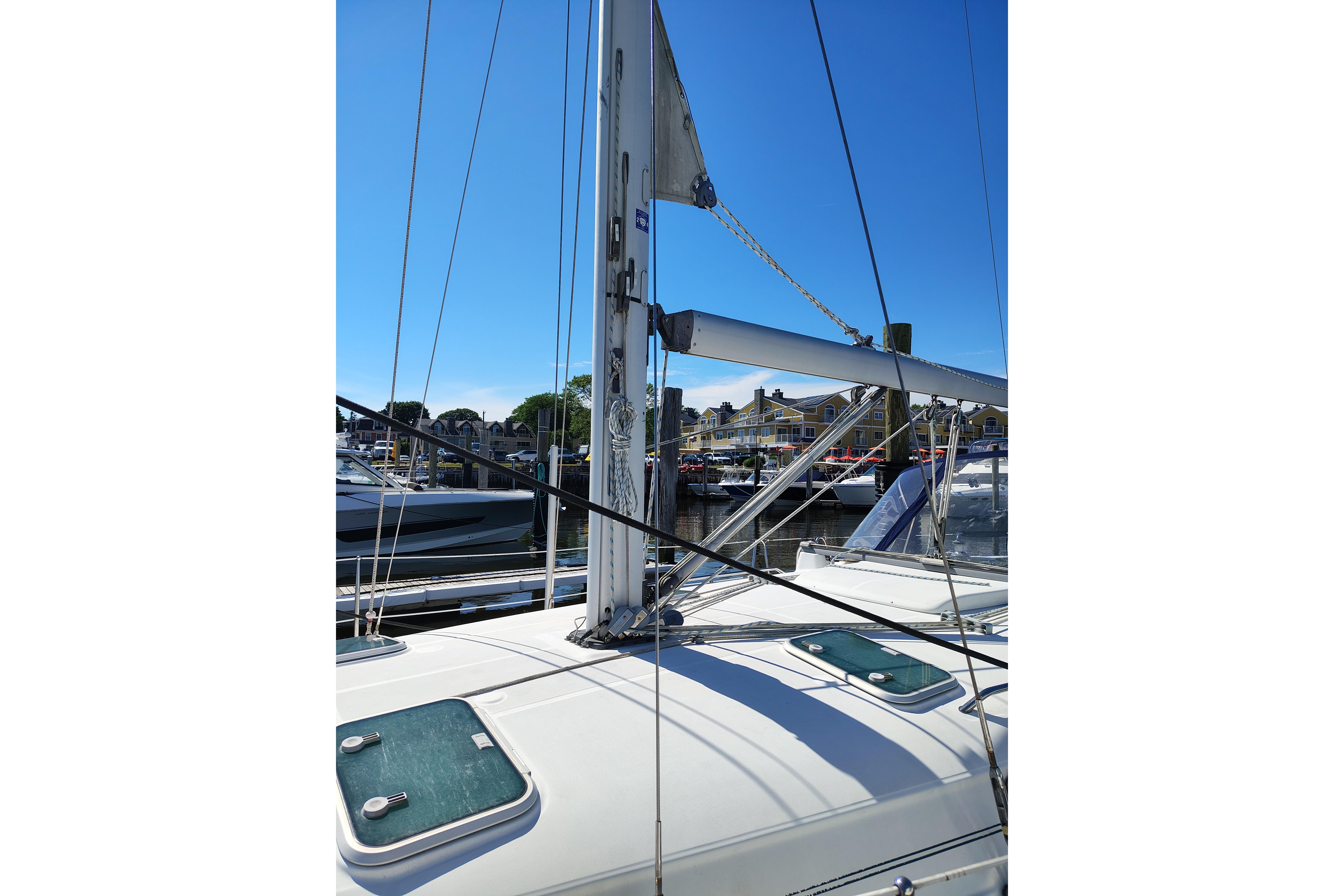 2001 Beneteau Oceanis 411 sailboat mast and deck in a marina setting.