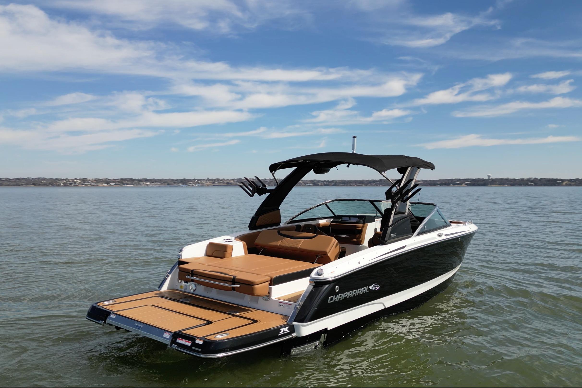 2023 Chaparral 26 Surf boat on calm water under a clear sky.