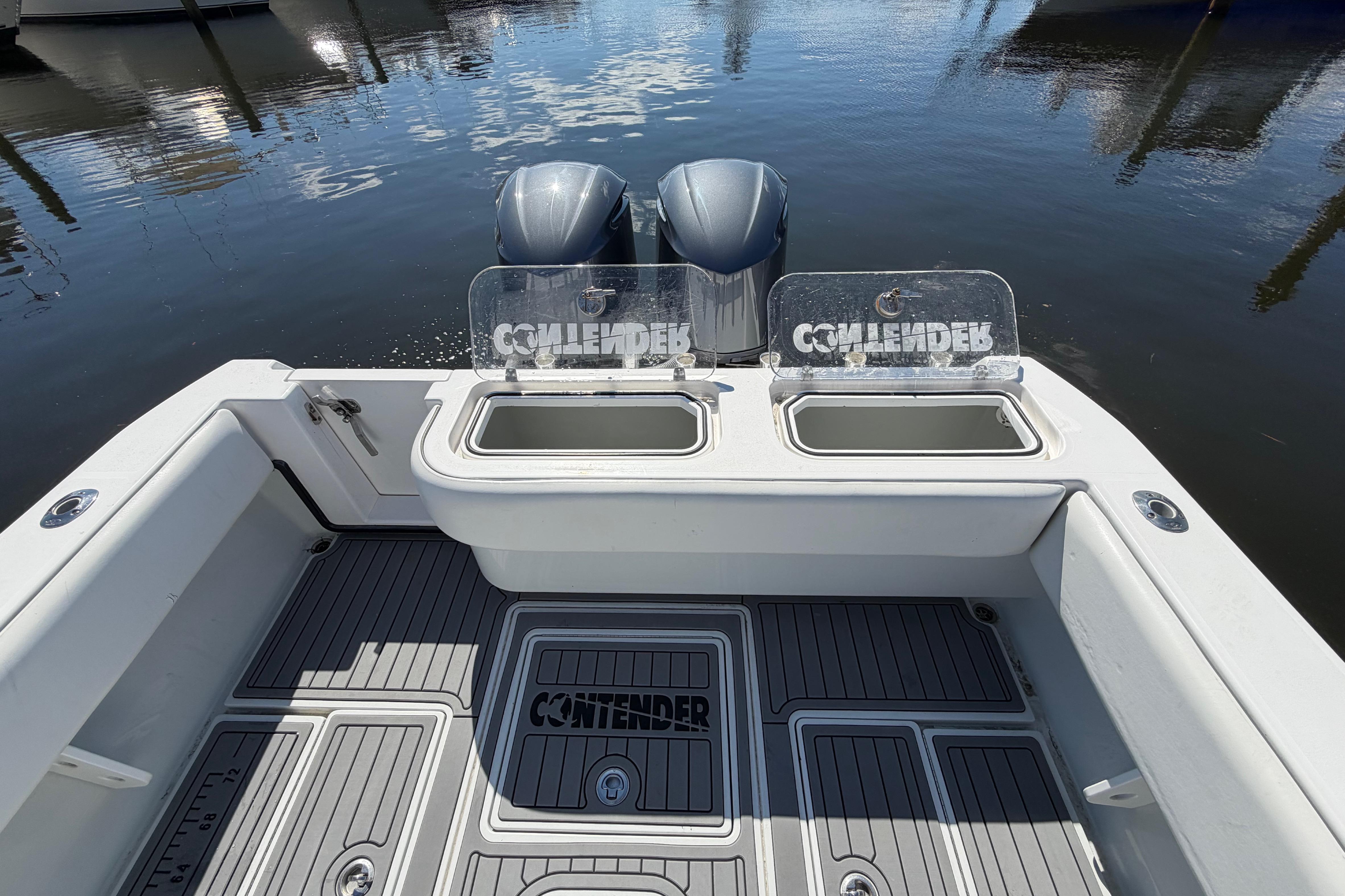 2015 Contender 32 ST boat with dual engines and open deck, docked on calm water.