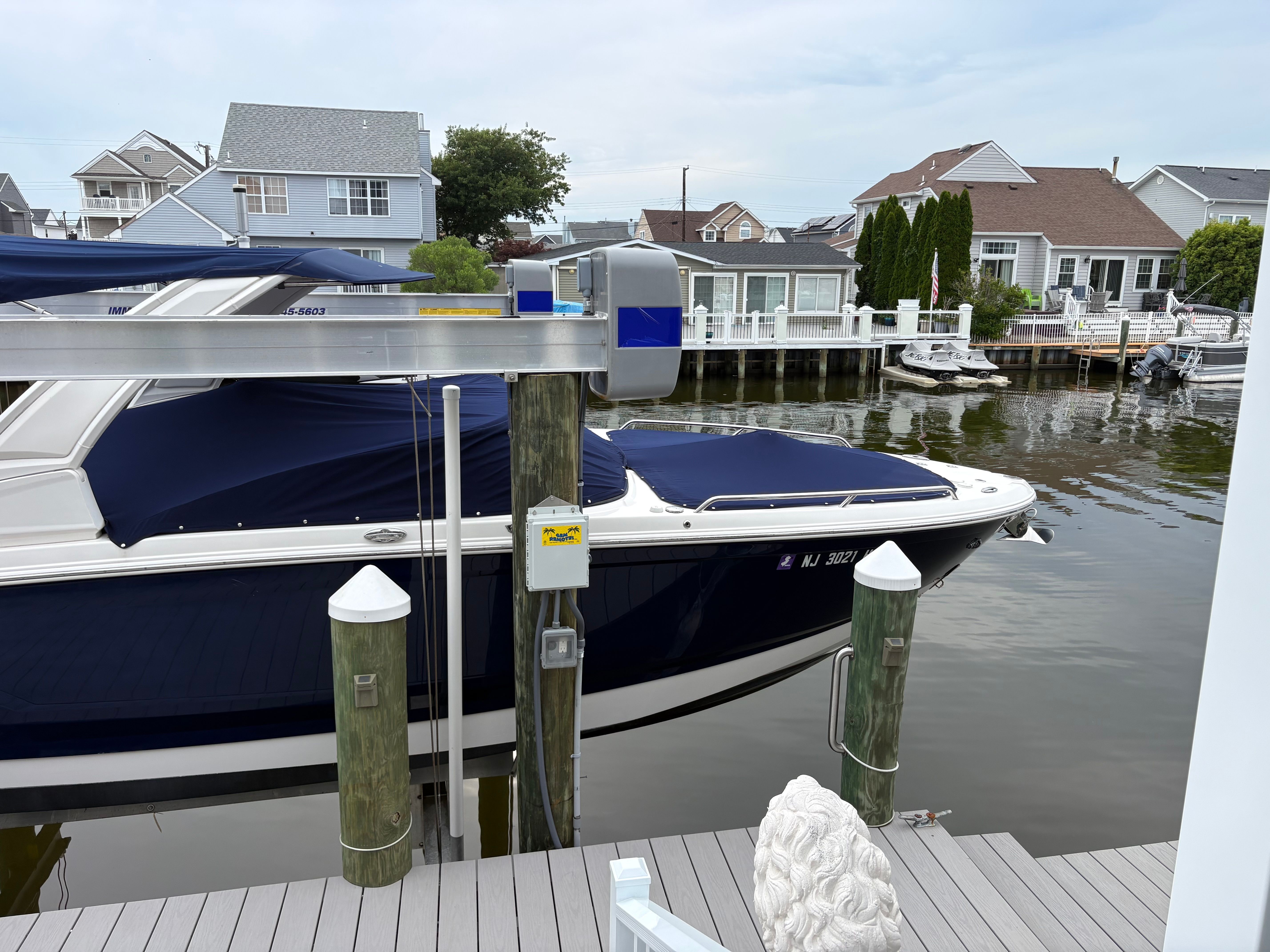 A 2019 Chaparral SSX277 boat docked in a calm residential area.
