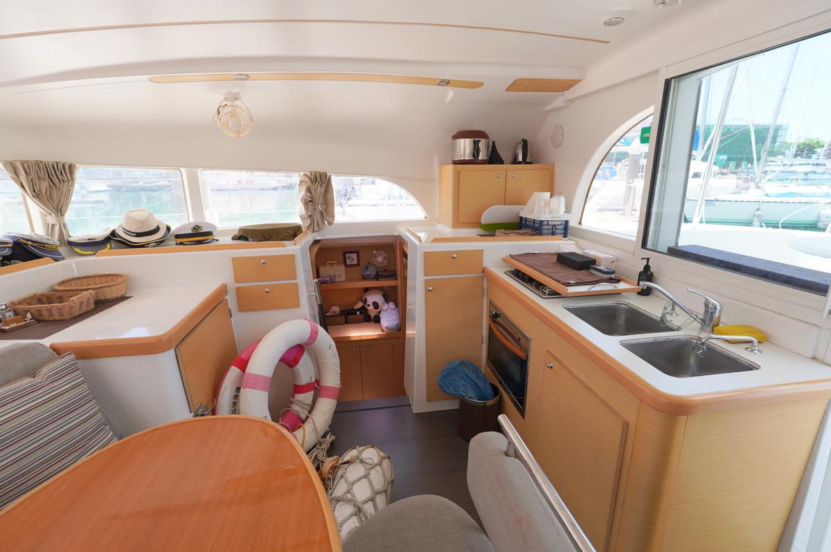 Interior of 2013 Lagoon 380 catamaran with kitchen, dining area, and nautical decor.