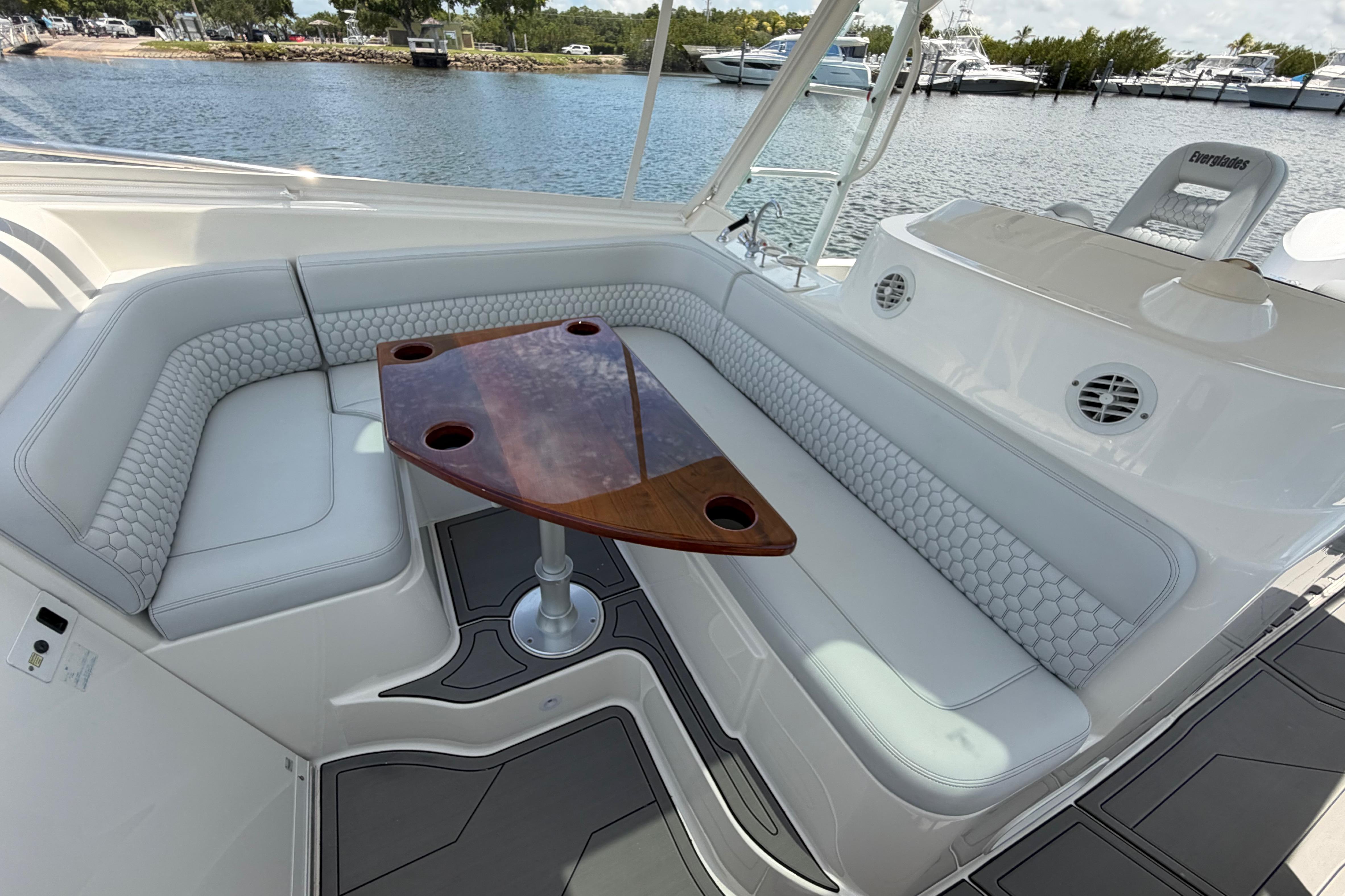 Luxurious seating area on a 2009 Everglades 350LX boat with elegant wood table.