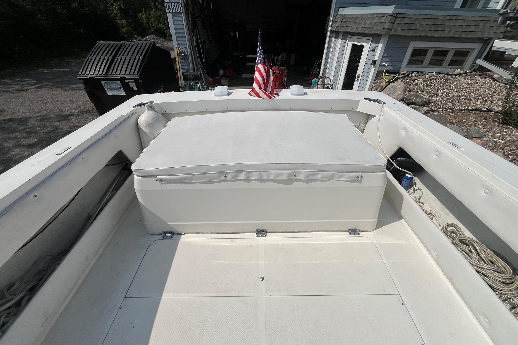 1975 Bertram 26 Moppie boat interior with American flag, docked near a house.
