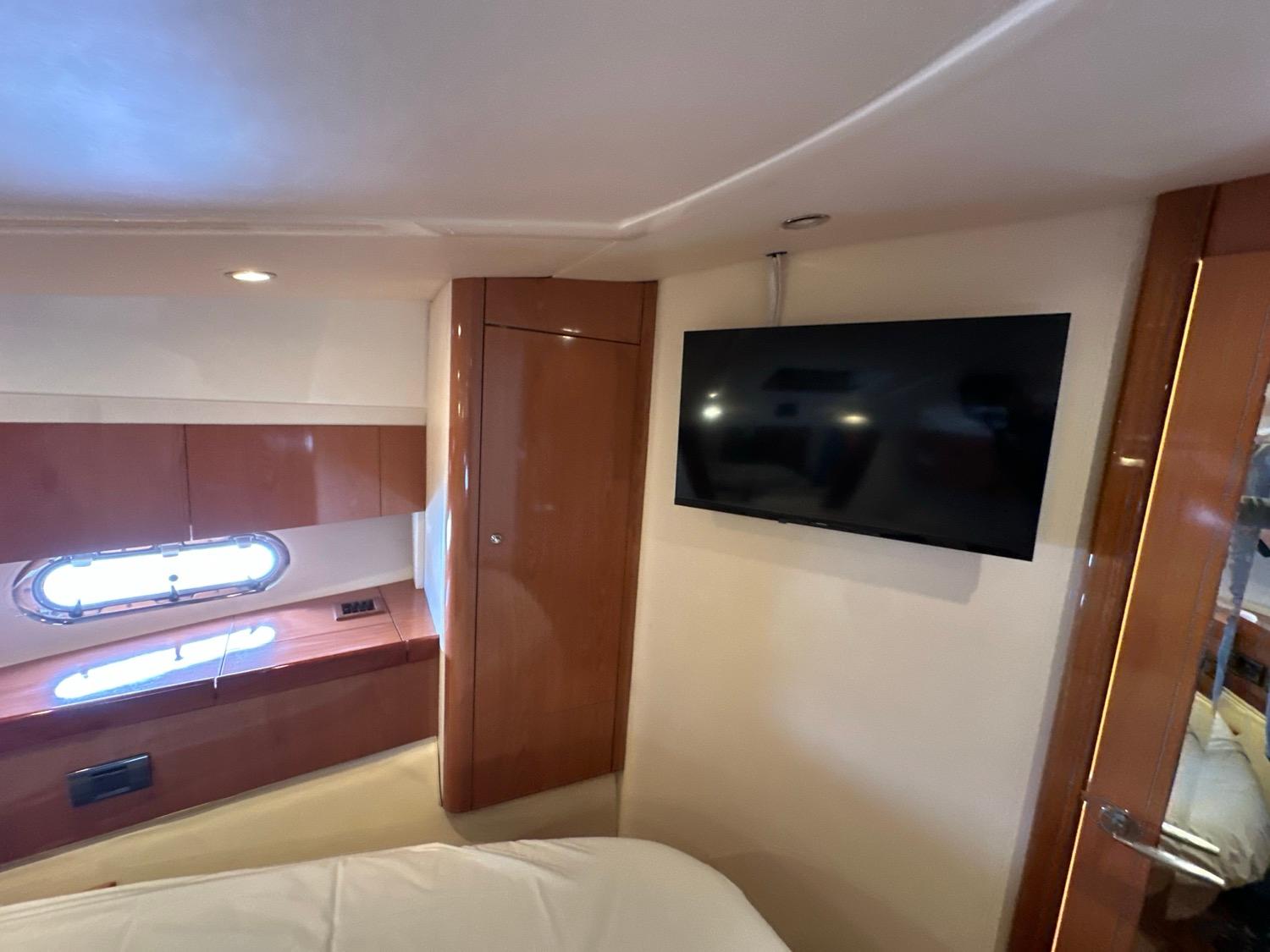 Interior of 2007 Sealine F42/5 yacht cabin with TV and porthole window.