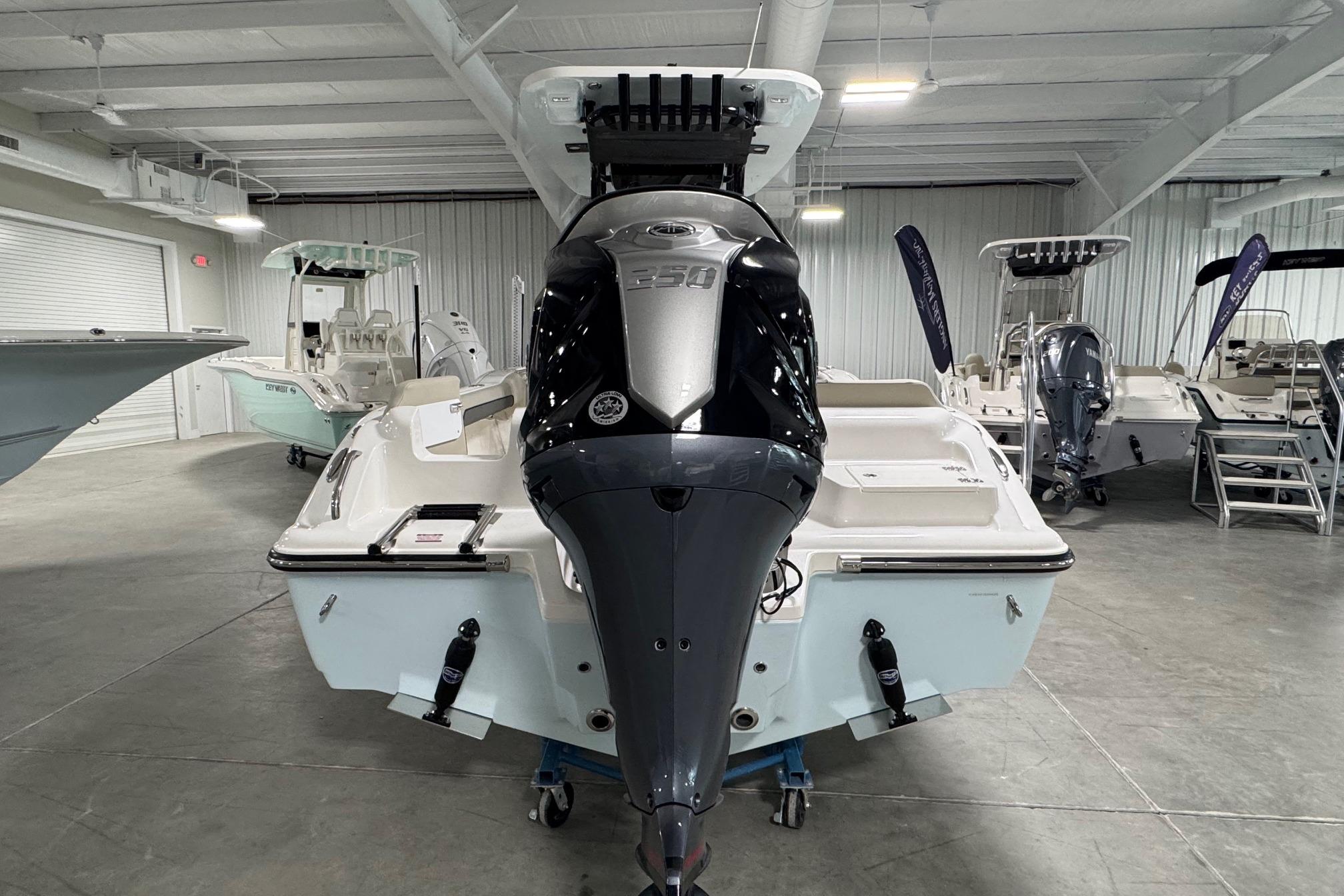2026 Key West 239 FS boat with powerful outboard motor in showroom.