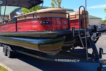 2026 Regency 250 DL pontoon boat on trailer, featuring sleek red design and modern amenities.