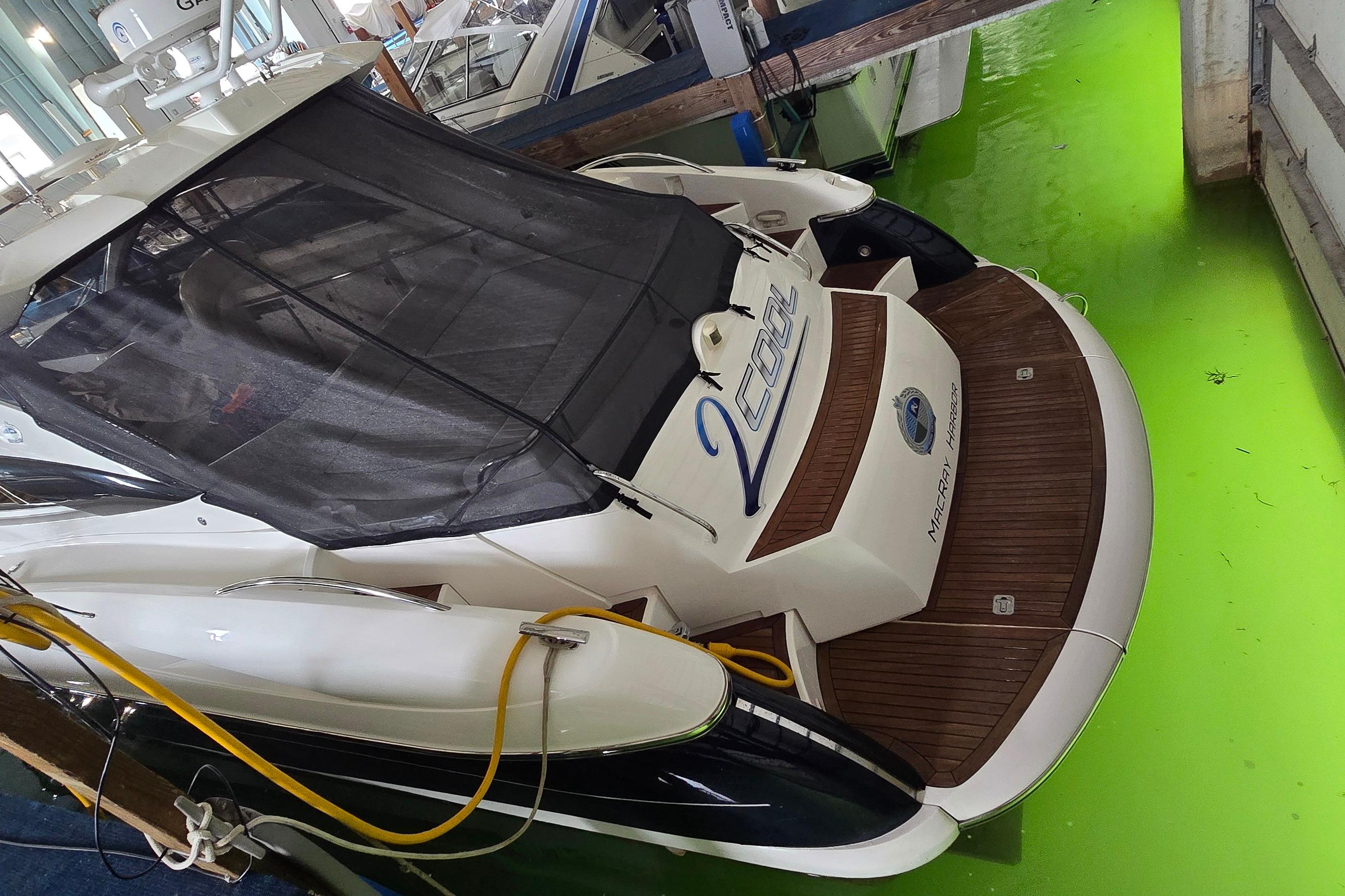 2004 Sunseeker Camargue 50 yacht docked in vibrant green water.
