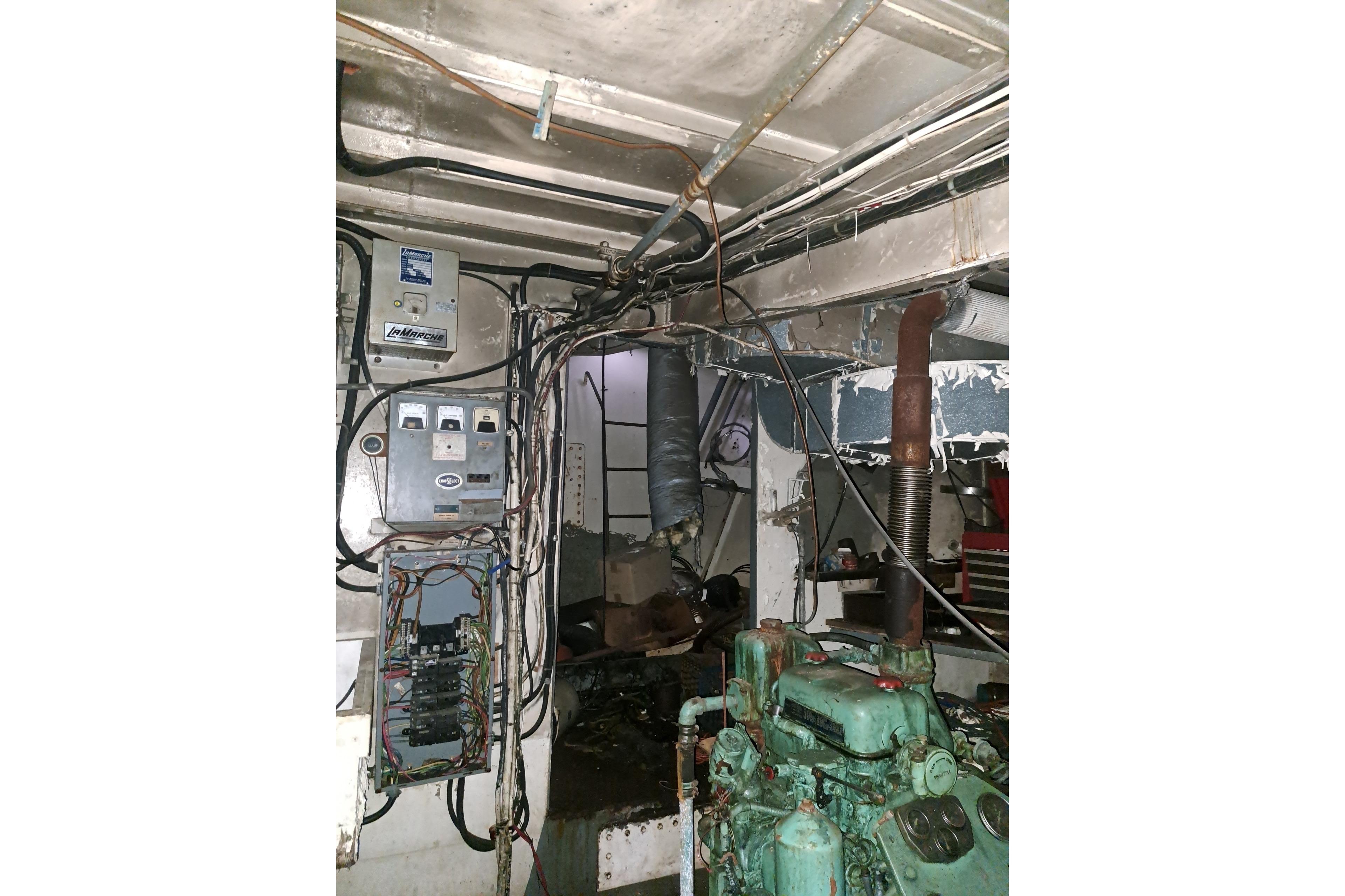 Engine room of a 1979 Custom Steel Trawler Dragger with visible wiring and machinery.