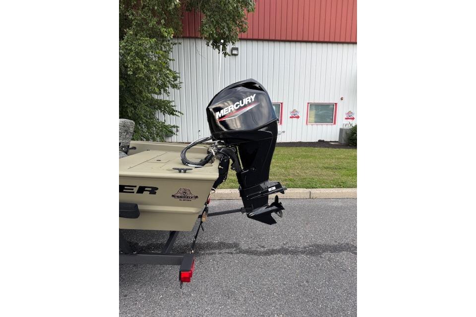 2026 Tracker Grizzly 1754 SC boat with Mercury outboard motor, parked outdoors.
