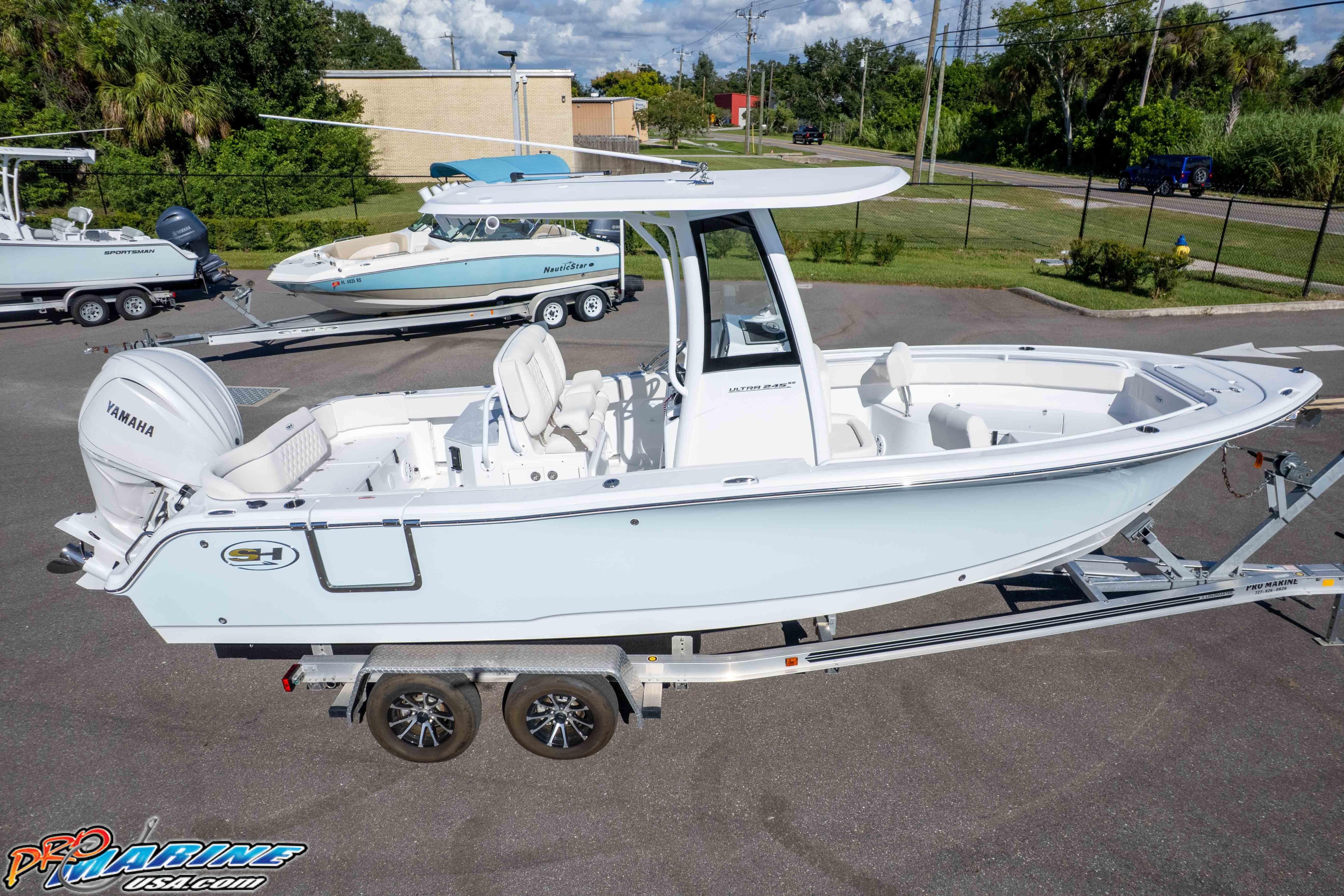 2025 Sea Hunt Ultra 245 SE boat on trailer, featuring Yamaha engine, parked outdoors.