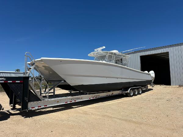 2022 Freeman 42LR boat on trailer, parked outside a large metal building.