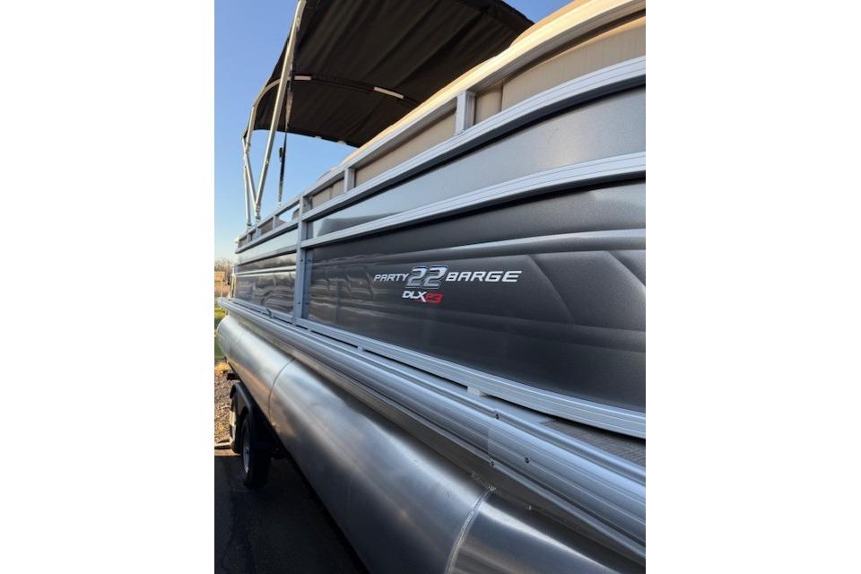 2025 Sun Tracker Party Barge 22 XP3 pontoon boat with sleek design and canopy.