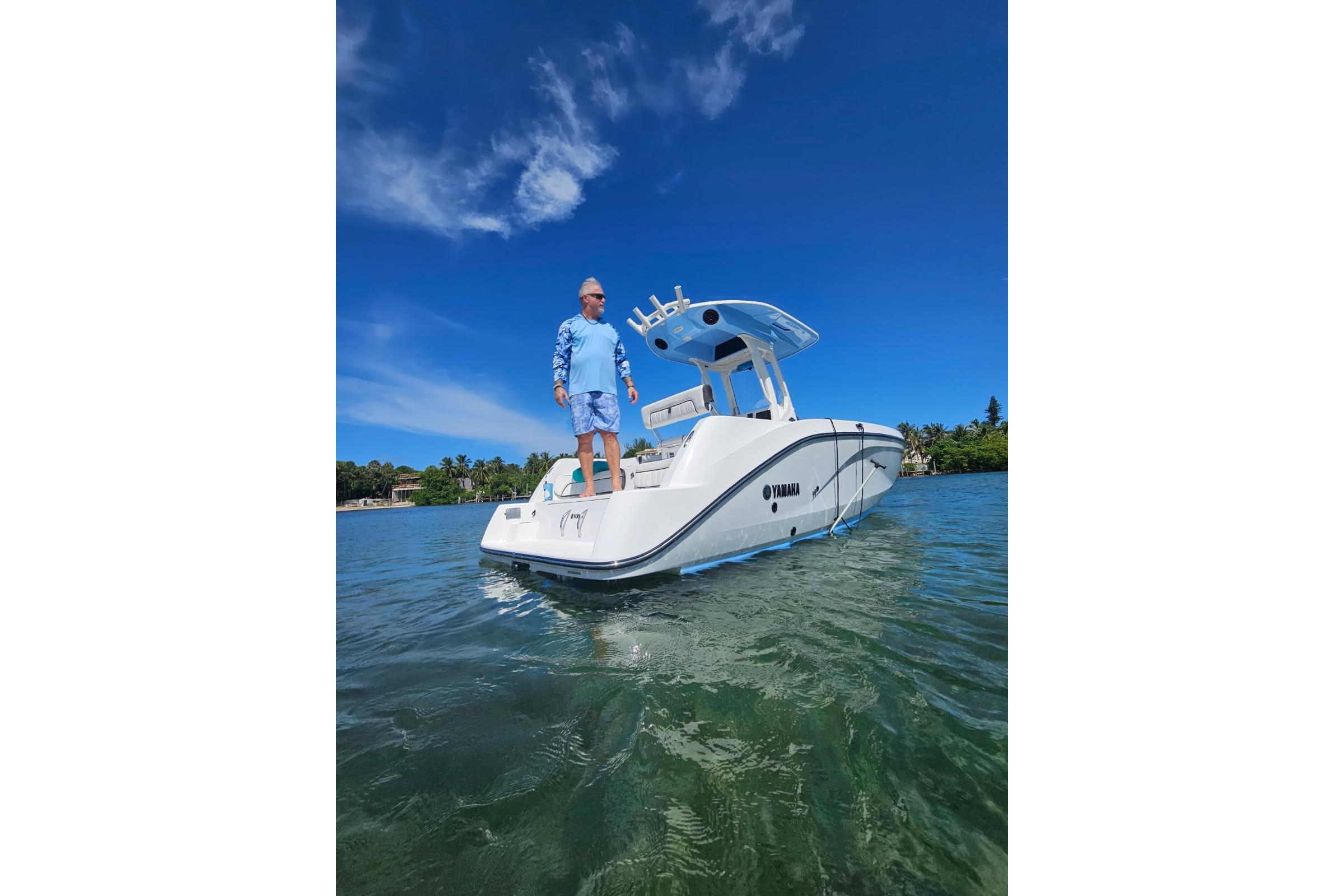2024 Yamaha Boats 222 FSH Sport E on clear water under blue sky.