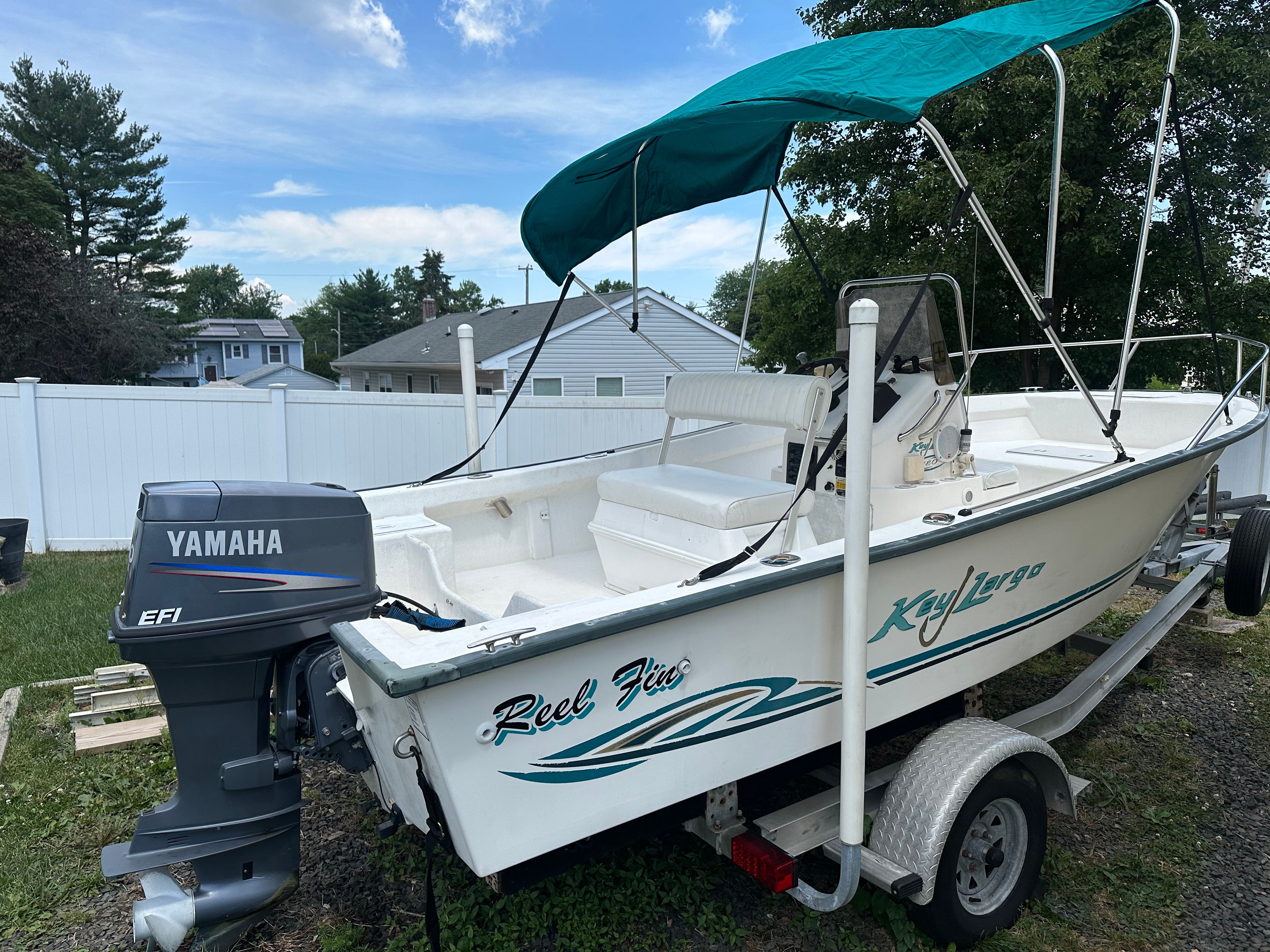 A 2003 Key Largo 180 Center Console boat with Yamaha outboard motor and green sunshade.