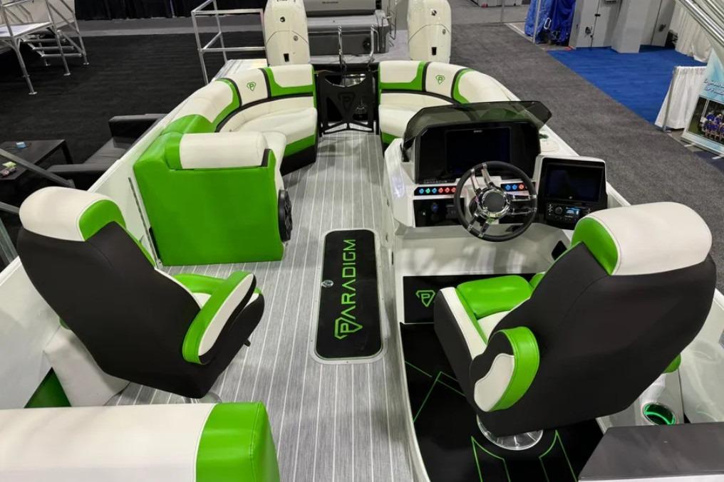 2025 Paradigm 25SS boat interior with green and white seating, modern dashboard, and steering wheel.