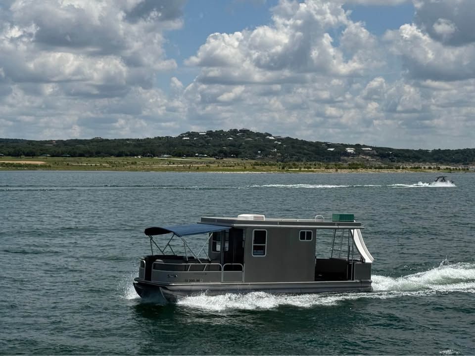 2008 Sun Tracker Party Cruiser on a lake under cloudy skies.
