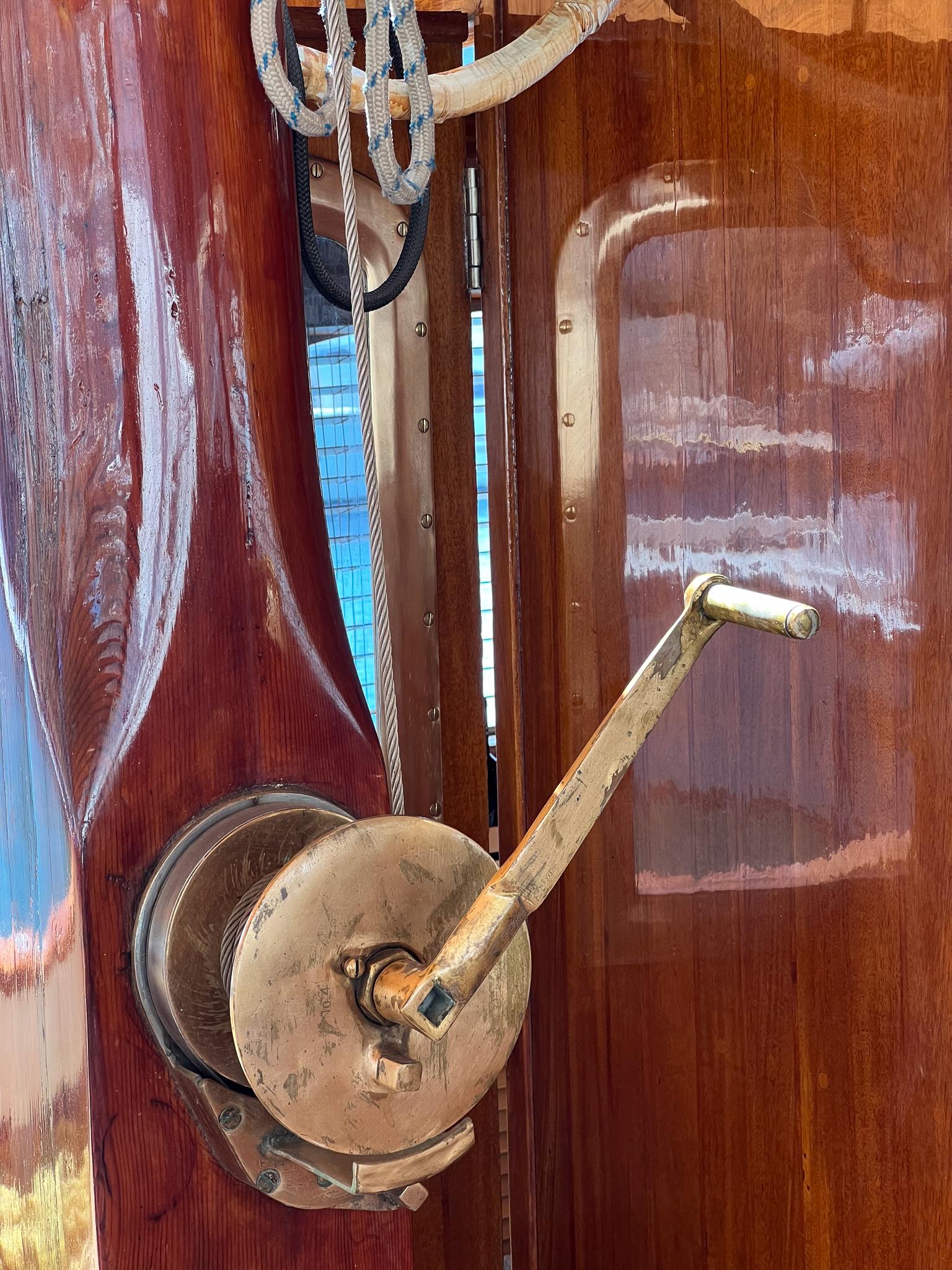 Vintage 1969 Psarros Shipyard boat winch with polished wood and brass handle.