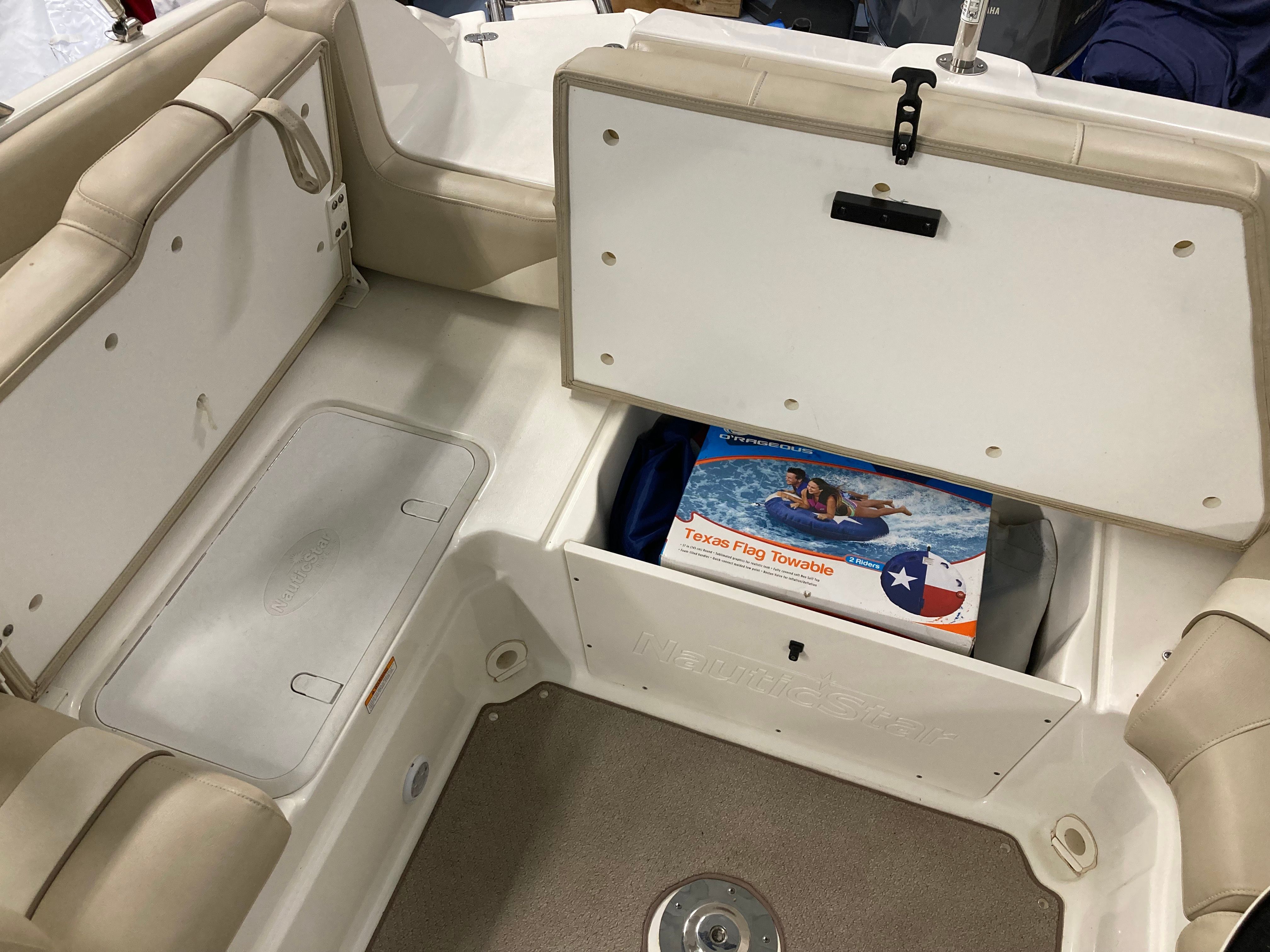 Boat interior with storage compartment and a Texas flag towable stored inside.