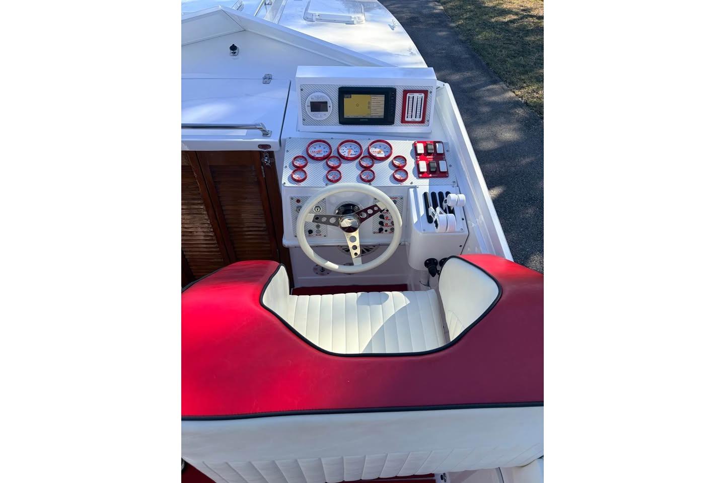 1983 Cigarette 24' Classic boat cockpit with red and white seating, steering wheel, and gauges.