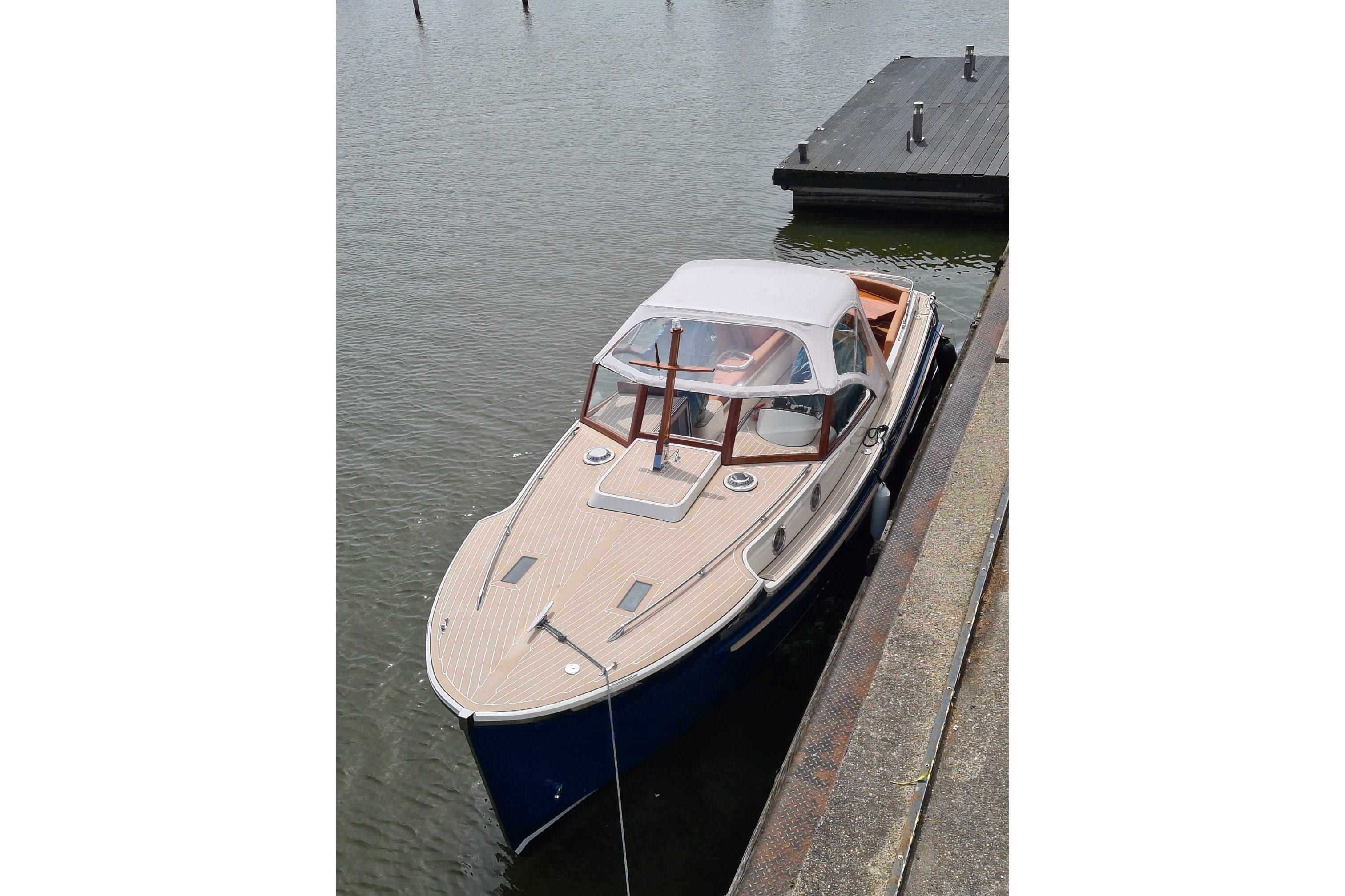 2022 STATEMENT MARINE PTS 26 boat docked on calm water.