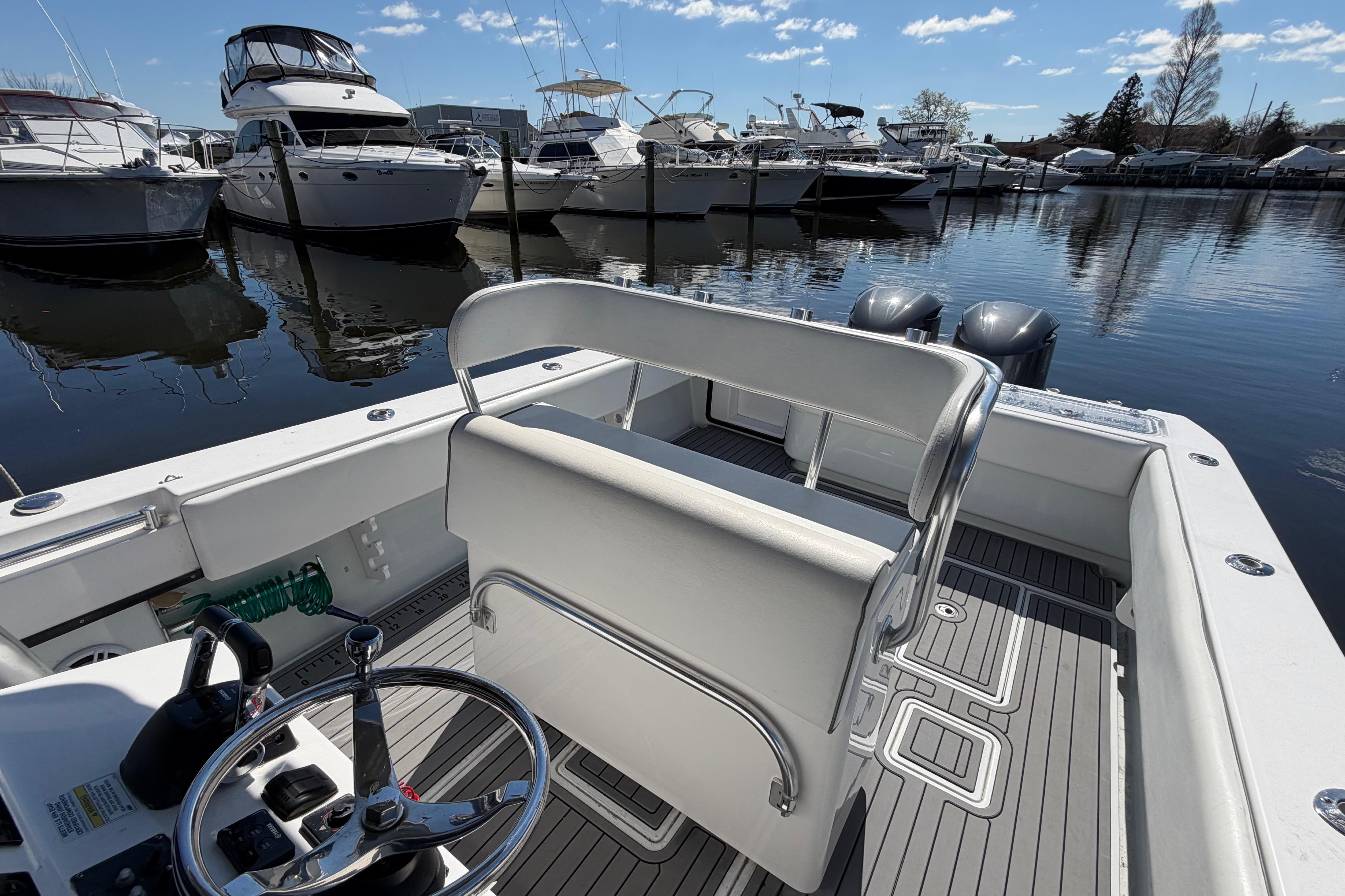 2015 Contender 32 ST boat docked at marina with clear skies and calm waters.