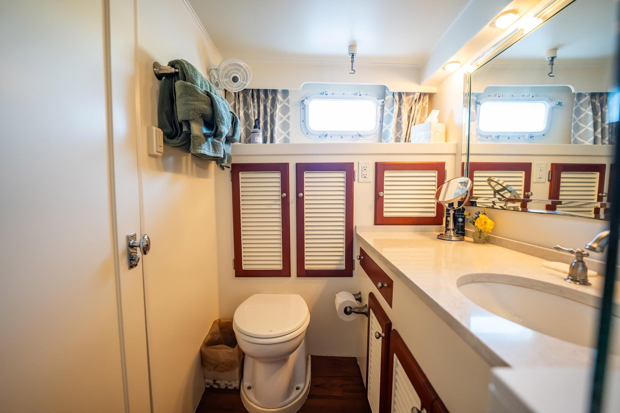 Bathroom interior of 1972 Trumpy 72 Motor Yacht with elegant fixtures and wooden accents.