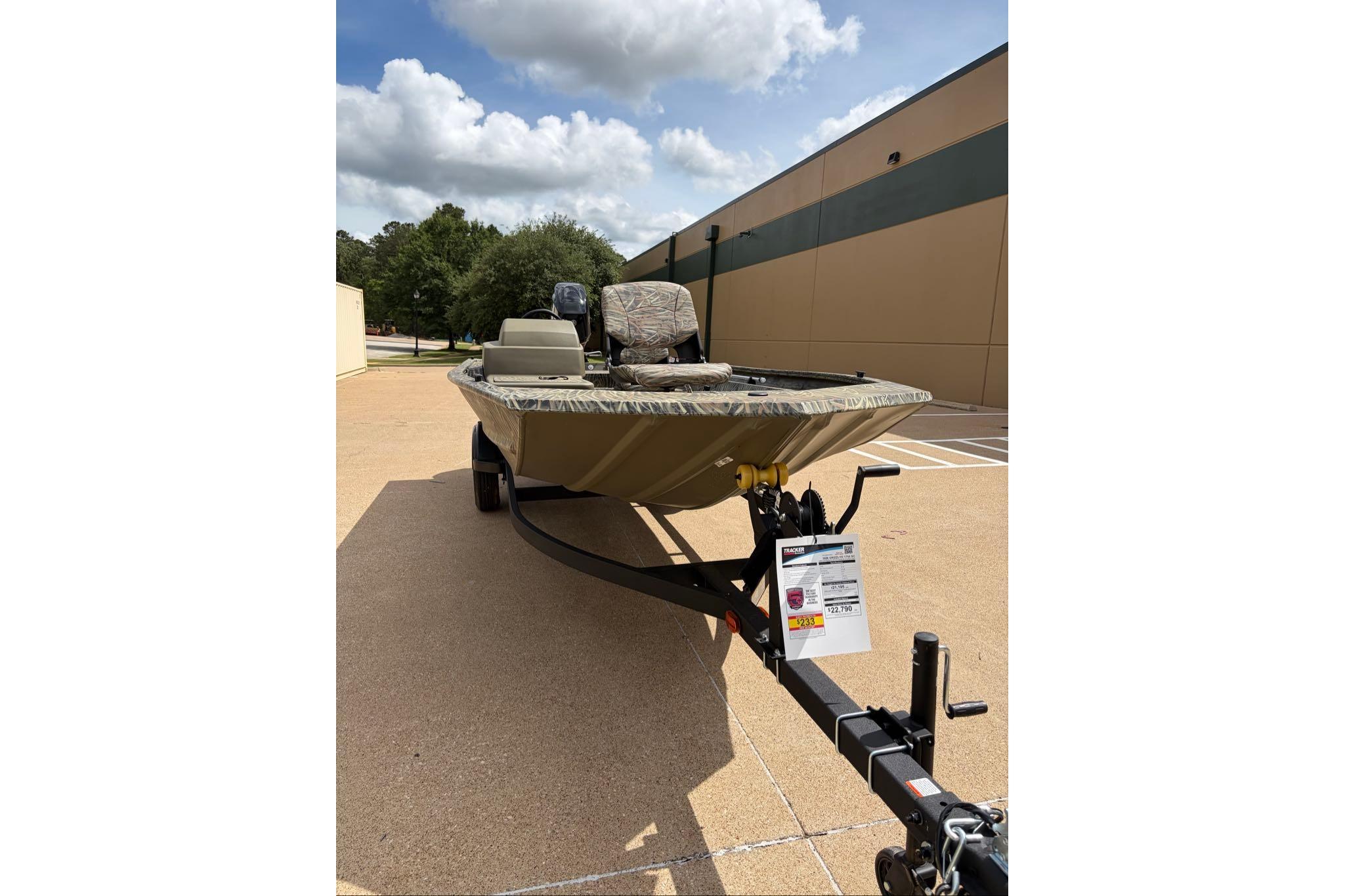 2026 Tracker Grizzly 1754 SC boat on trailer, parked outdoors under a partly cloudy sky.