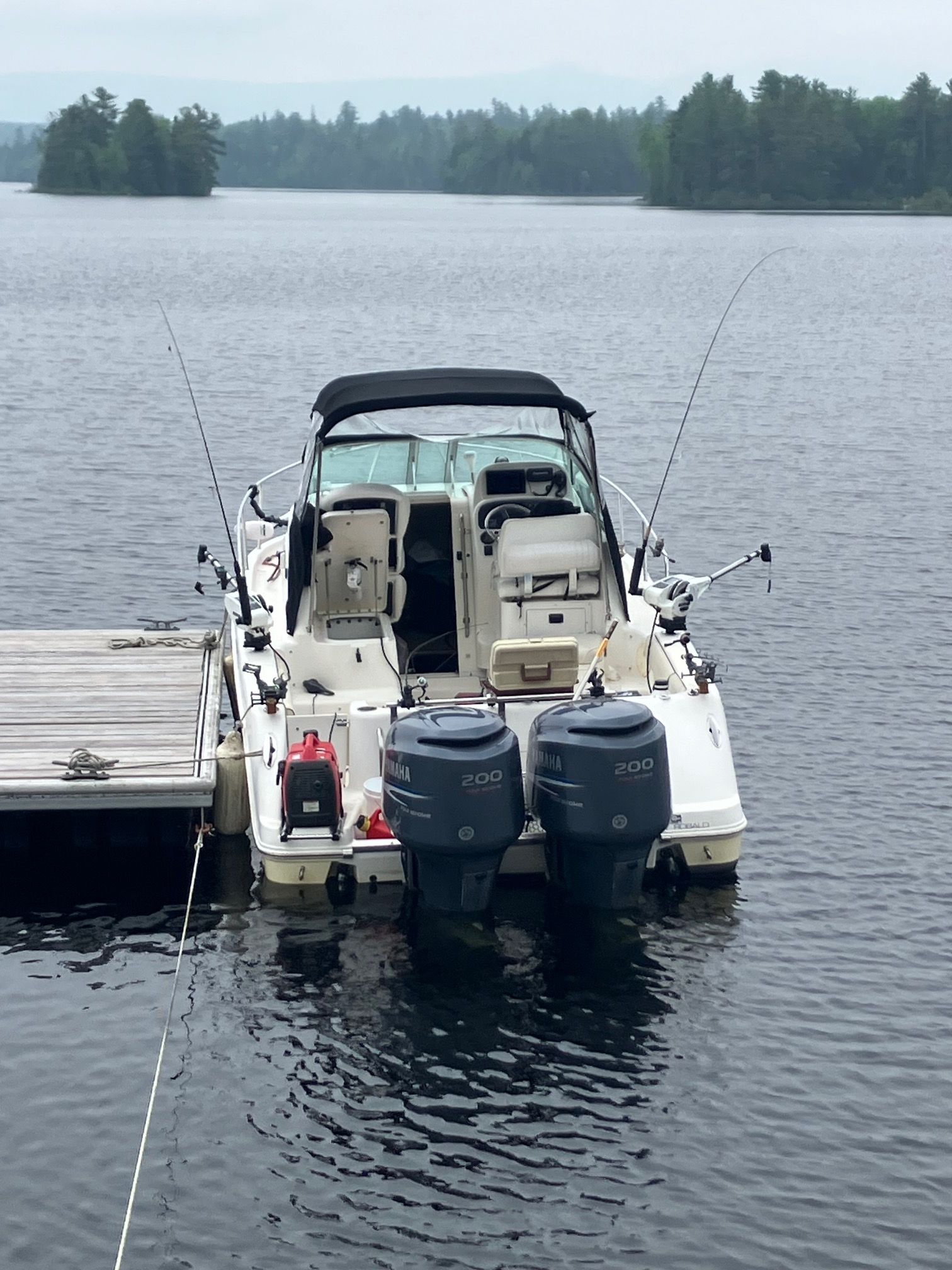 A 2006 Robalo R265 Walkaround docked on a calm lake.
