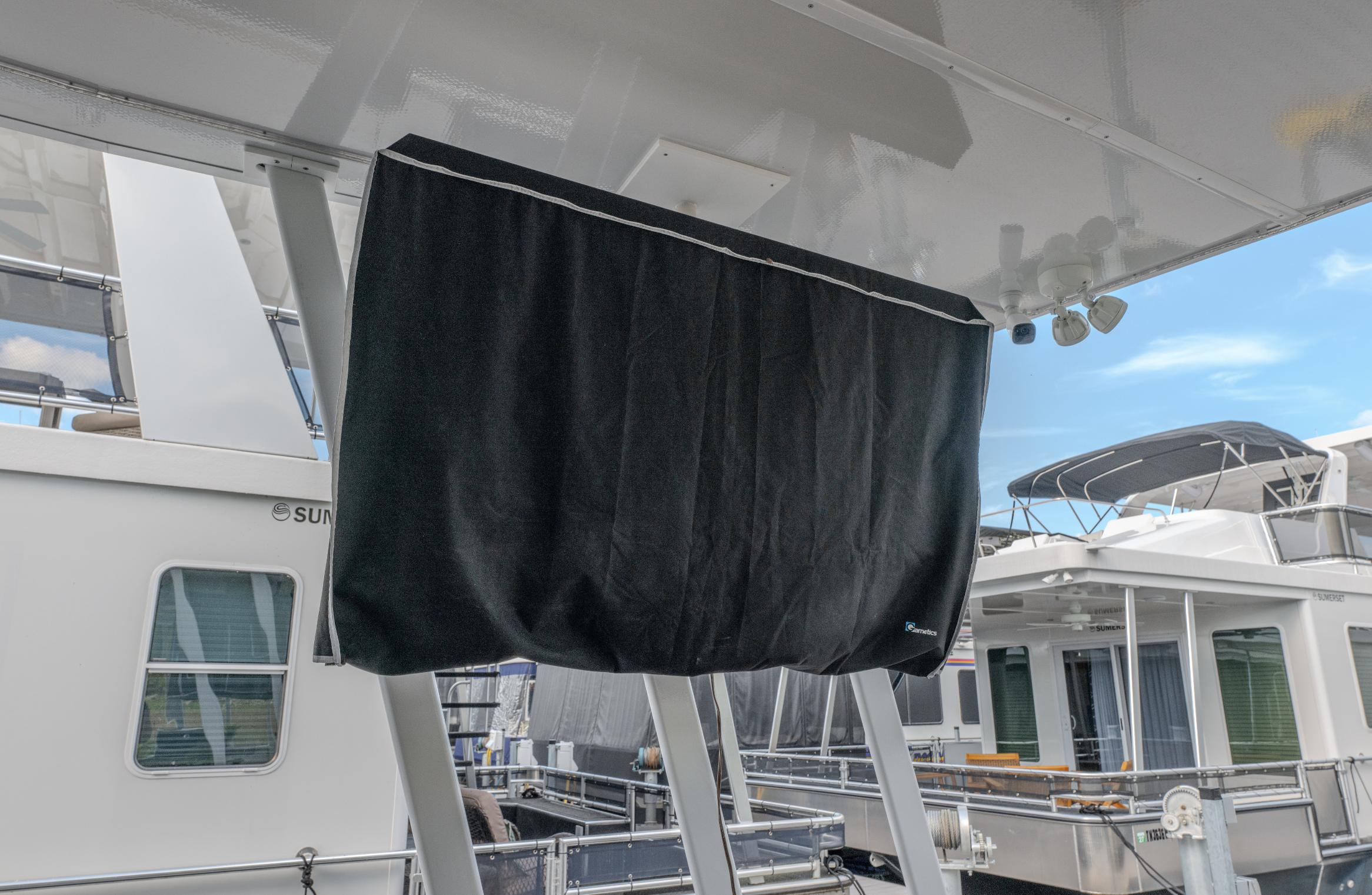 Covered equipment on a 2007 Fantasy 19 X 90 houseboat, docked with other boats.