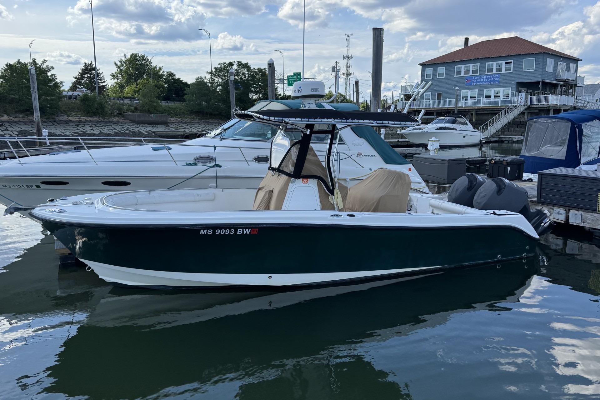 2007 Edgewater 245CC boat docked at marina, calm water, clear sky.