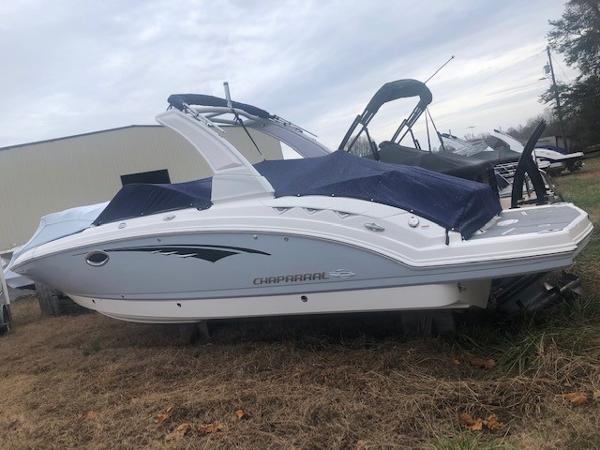 2019 Chaparral 264 Sunesta boat parked on dry grass.