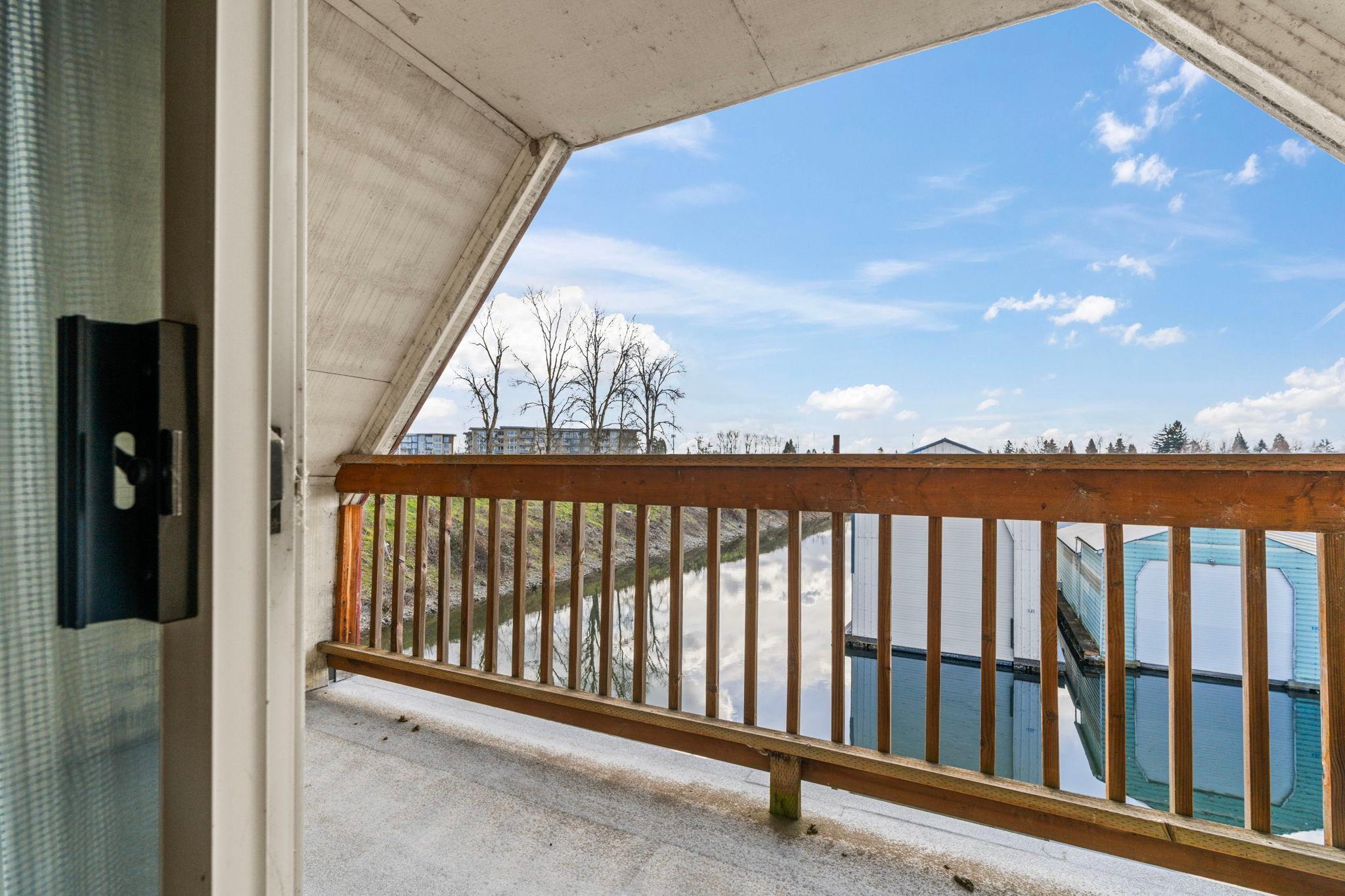 1976 Custom Boathouse balcony view overlooking serene water and clear blue sky.